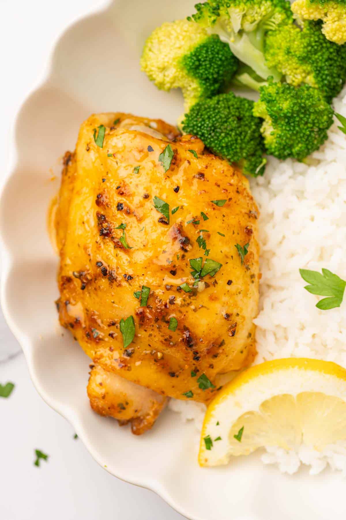 Baked Lemon pepper chicken Thighs in a plate with rice and broccoli