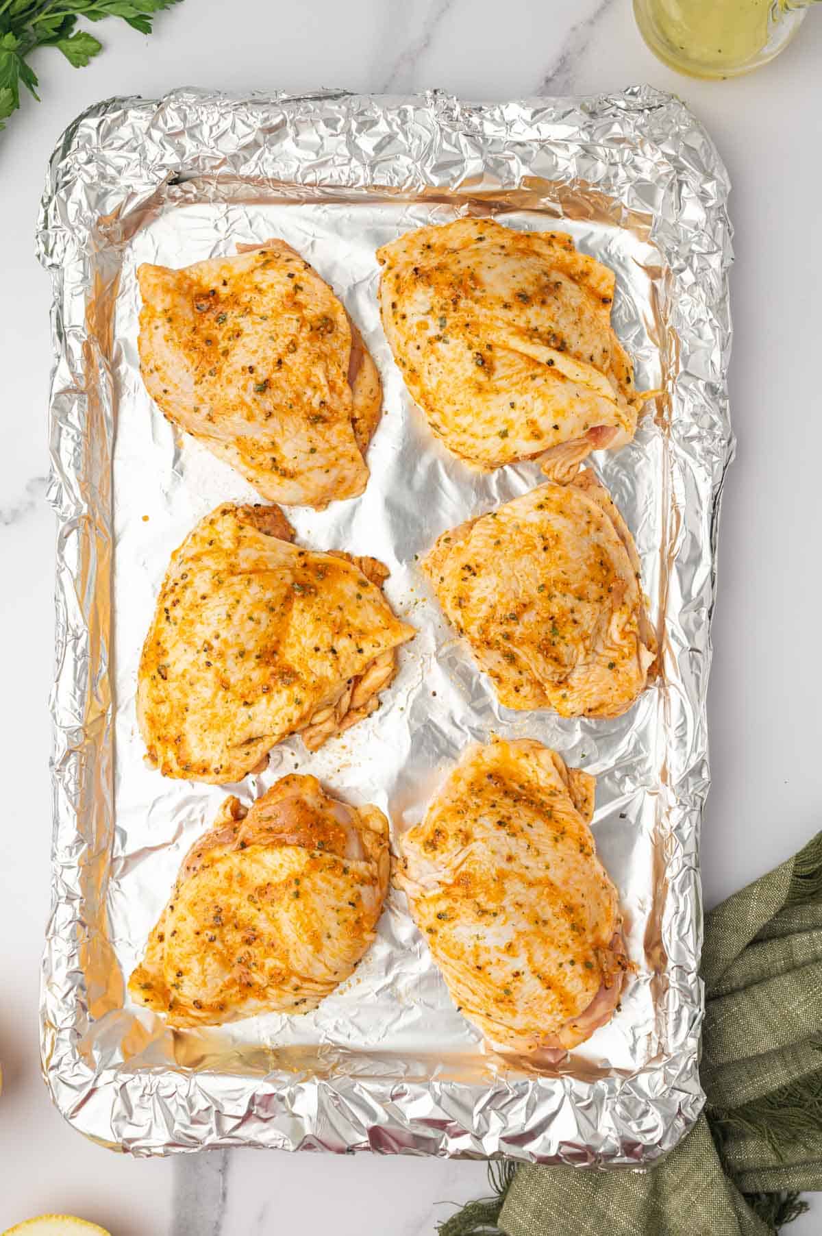 Arranged chicken thighs in a baking sheet