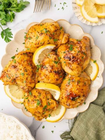 Lemon pepper chicken in a plate garnished with parsley