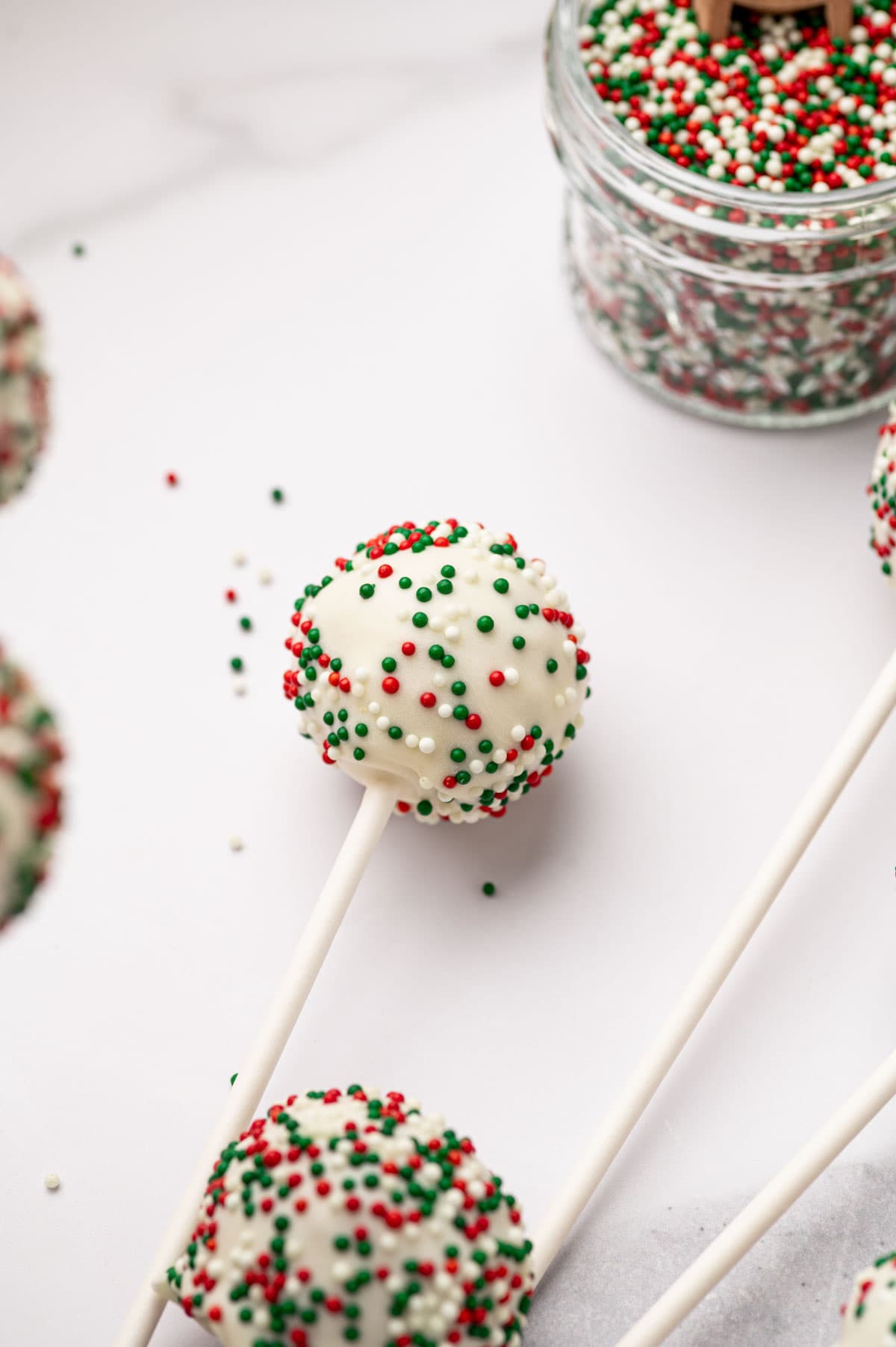 CHRISTMAS cake pops with sprinkles in the side