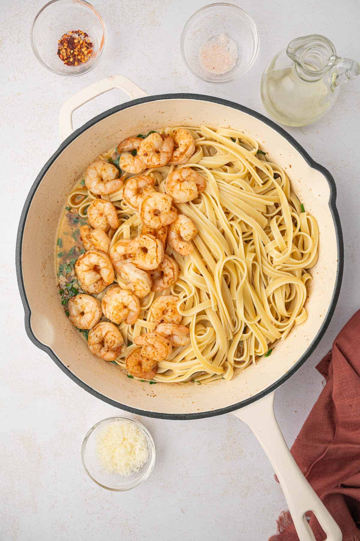 Cooked fettuccine pasta and cooked shrimp in a skillet