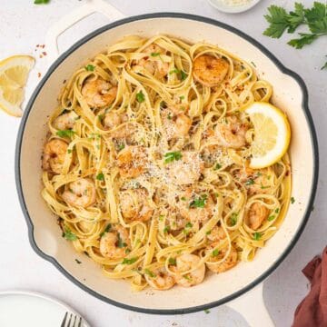 Easy shrimp scampi fettuccine in a white skillet and garnished with parsley