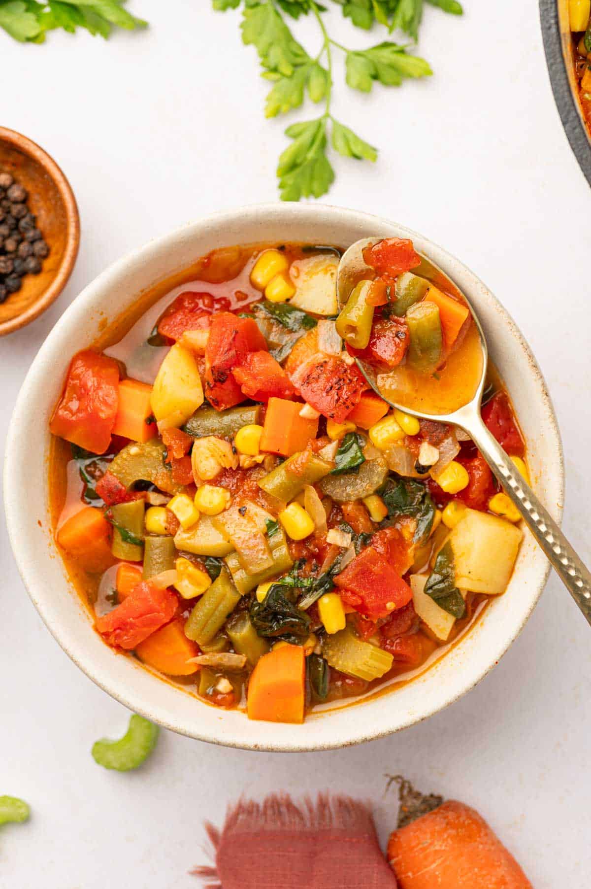 Spicy vegetable soup in a bowl with spoon