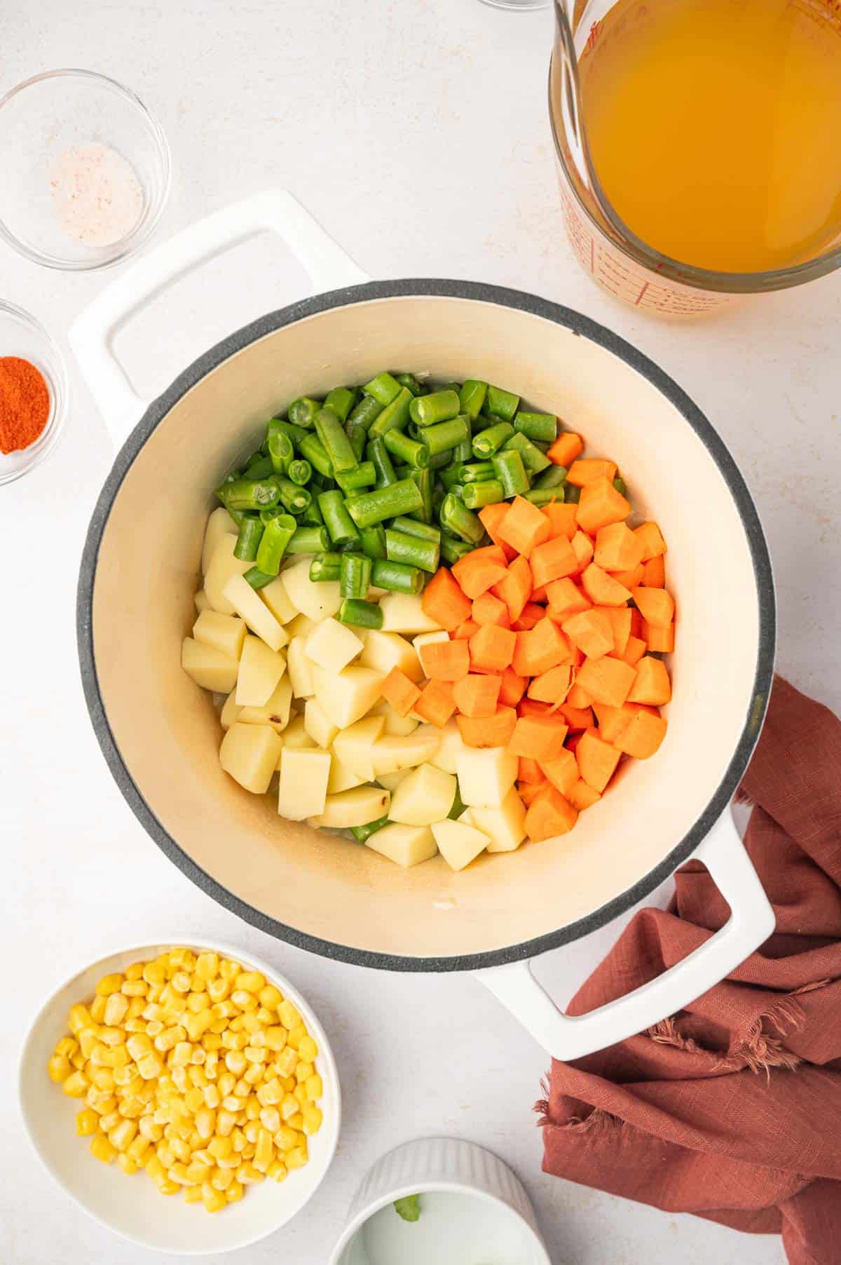 carrots, beans and potato in a dutch oven cooking