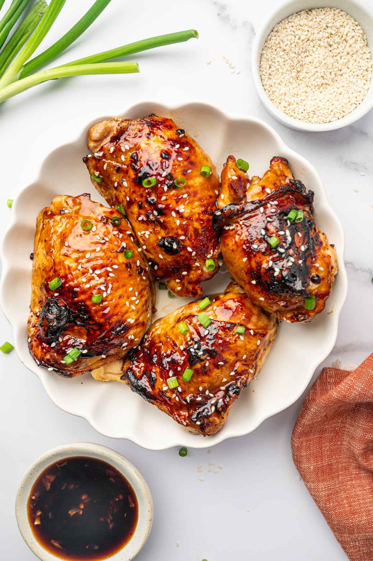 Perfectly Cooked Chicken Thighs in a Rich, Sticky Teriyaki Sauce in a white plate.