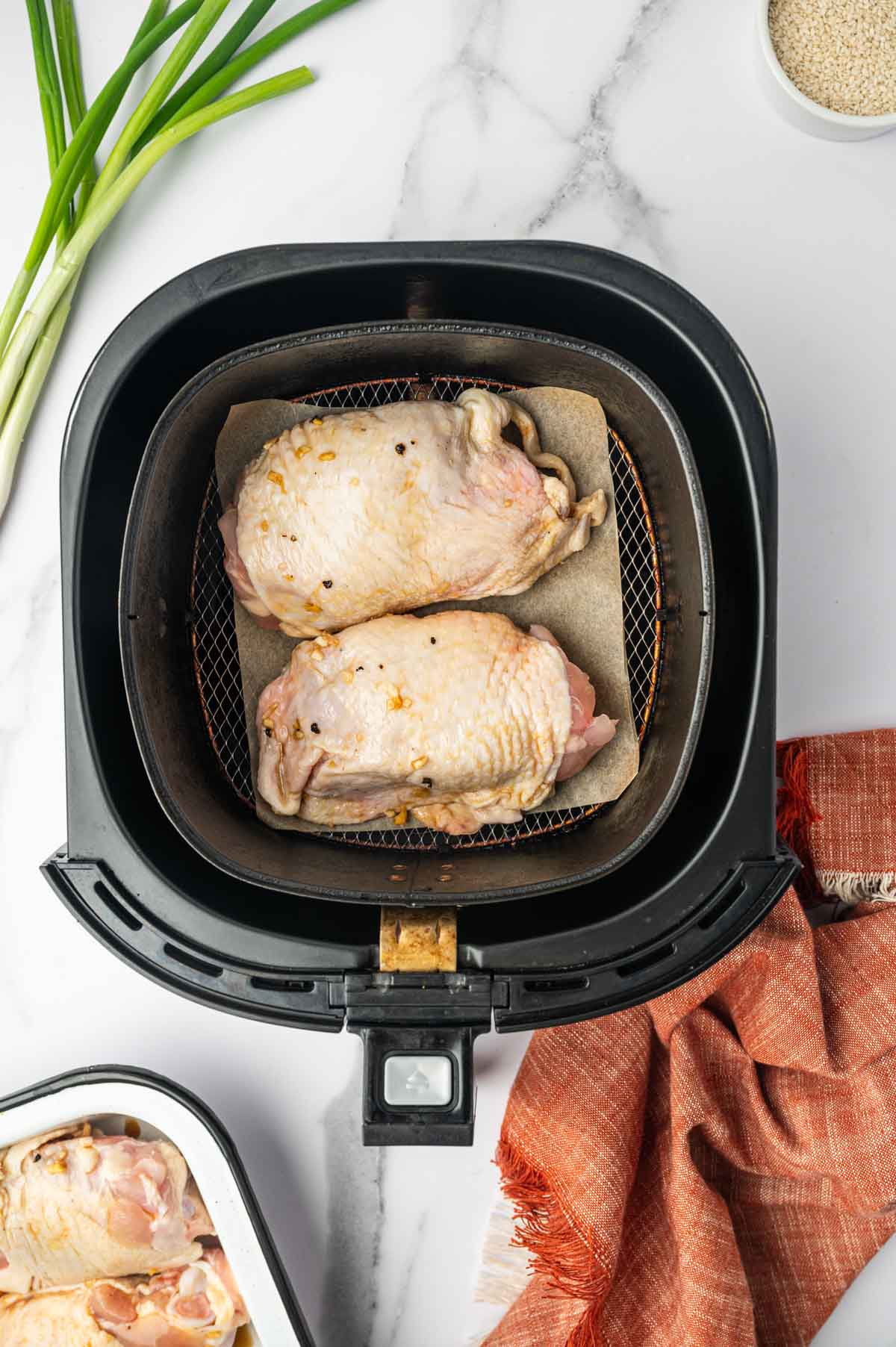 Air Fryer Teriyaki Chicken Thighs uncooked in the air fryer basket.