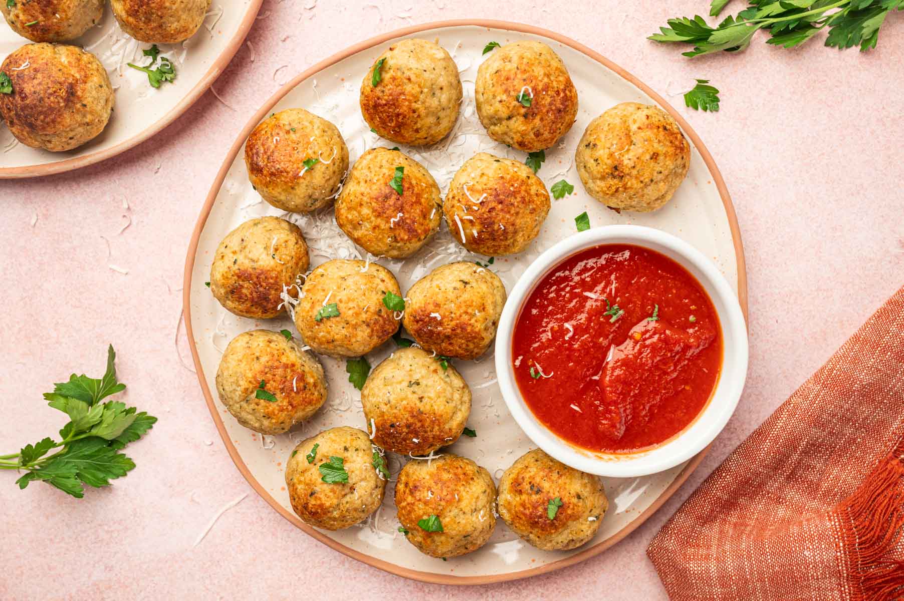 horizontal image of air fryer chicken meatballs in a white plate with sauce.