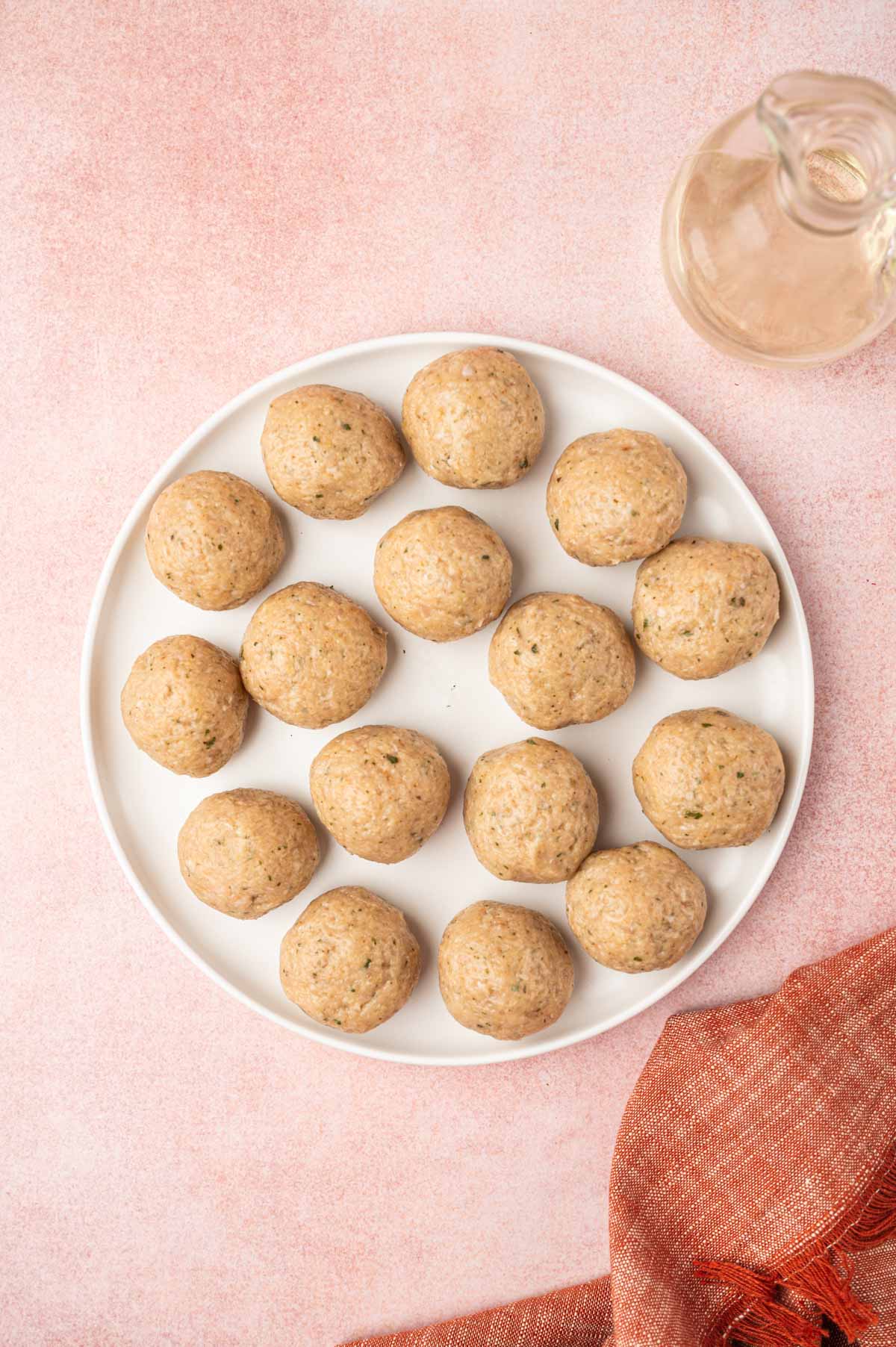 Chicken meatballs shaped into balls placed in a white plate.