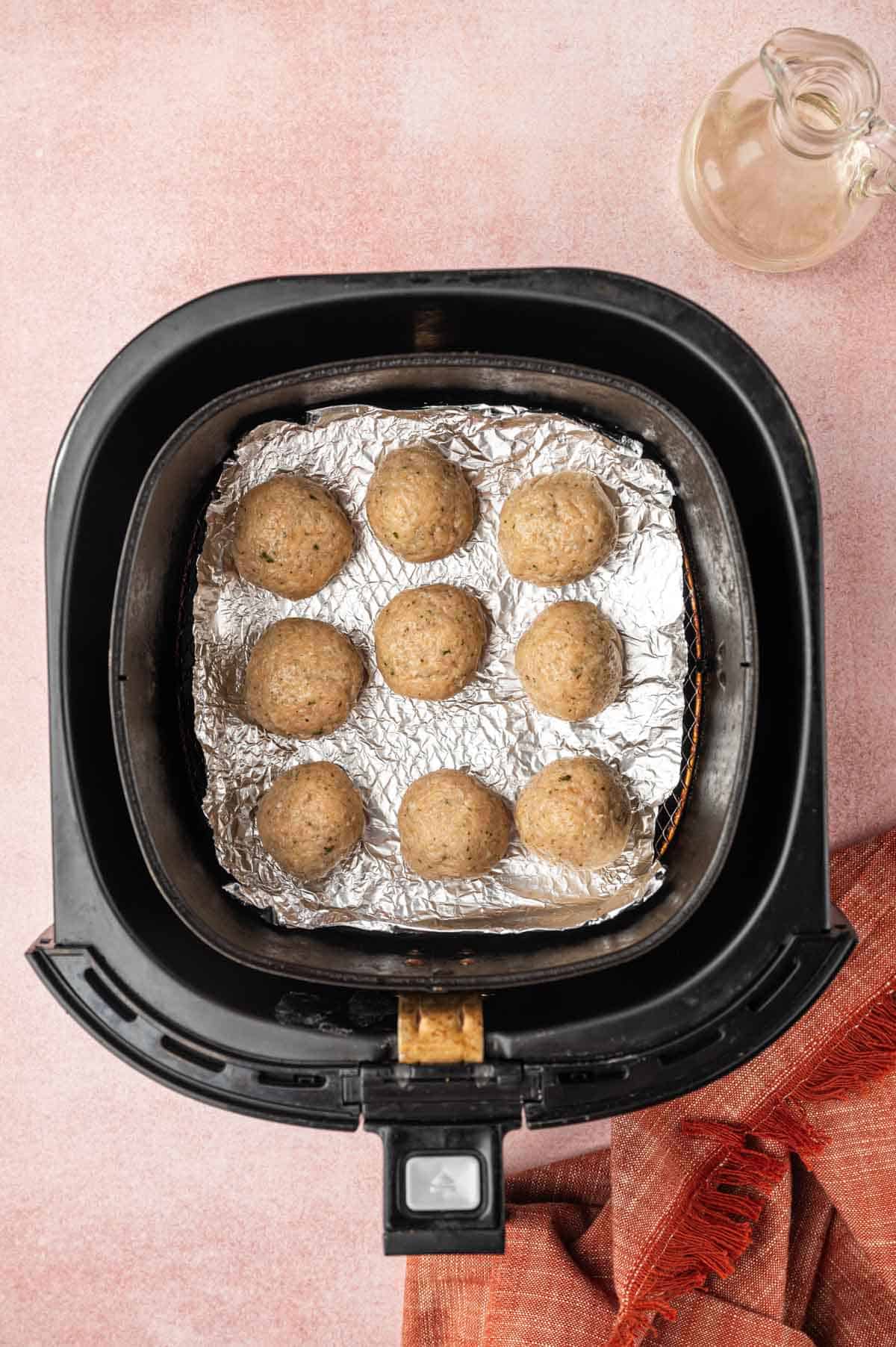 Chicken Meatballs ready to air fry in the air fryer basket.