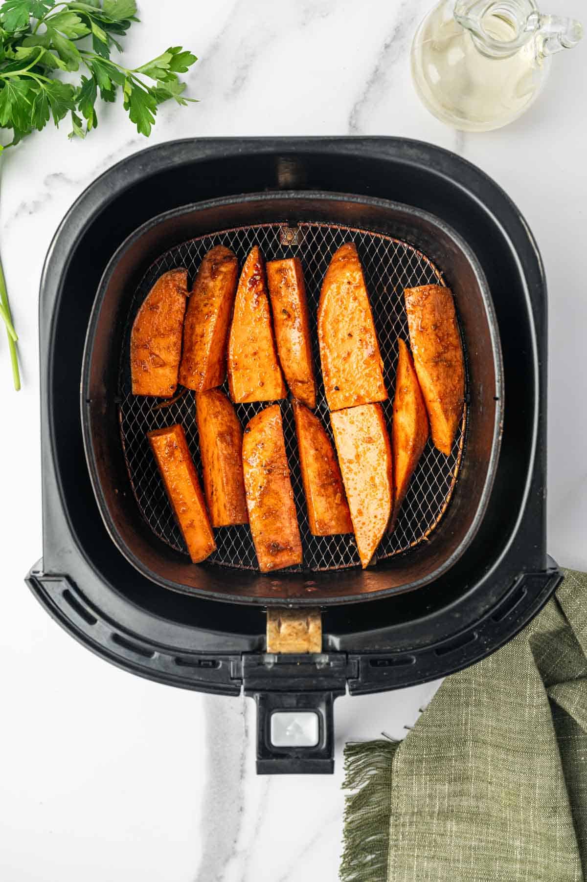 Arranged sweet potaoes in an air fryer.