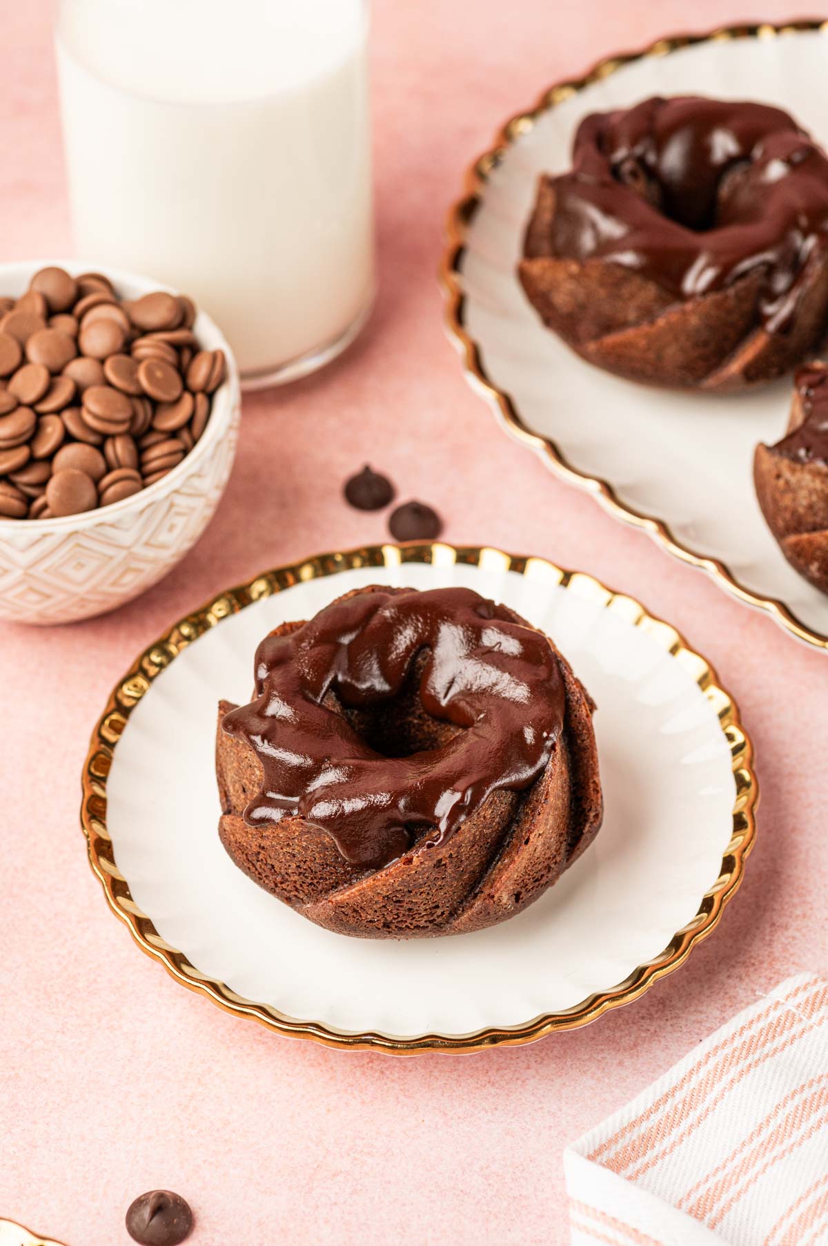 Mini chocolate bundt cake with chocolate ganache in a white plate.