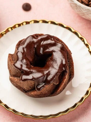 Close up shot of chocolate mini bundt cake with chocolate drizzle on it.