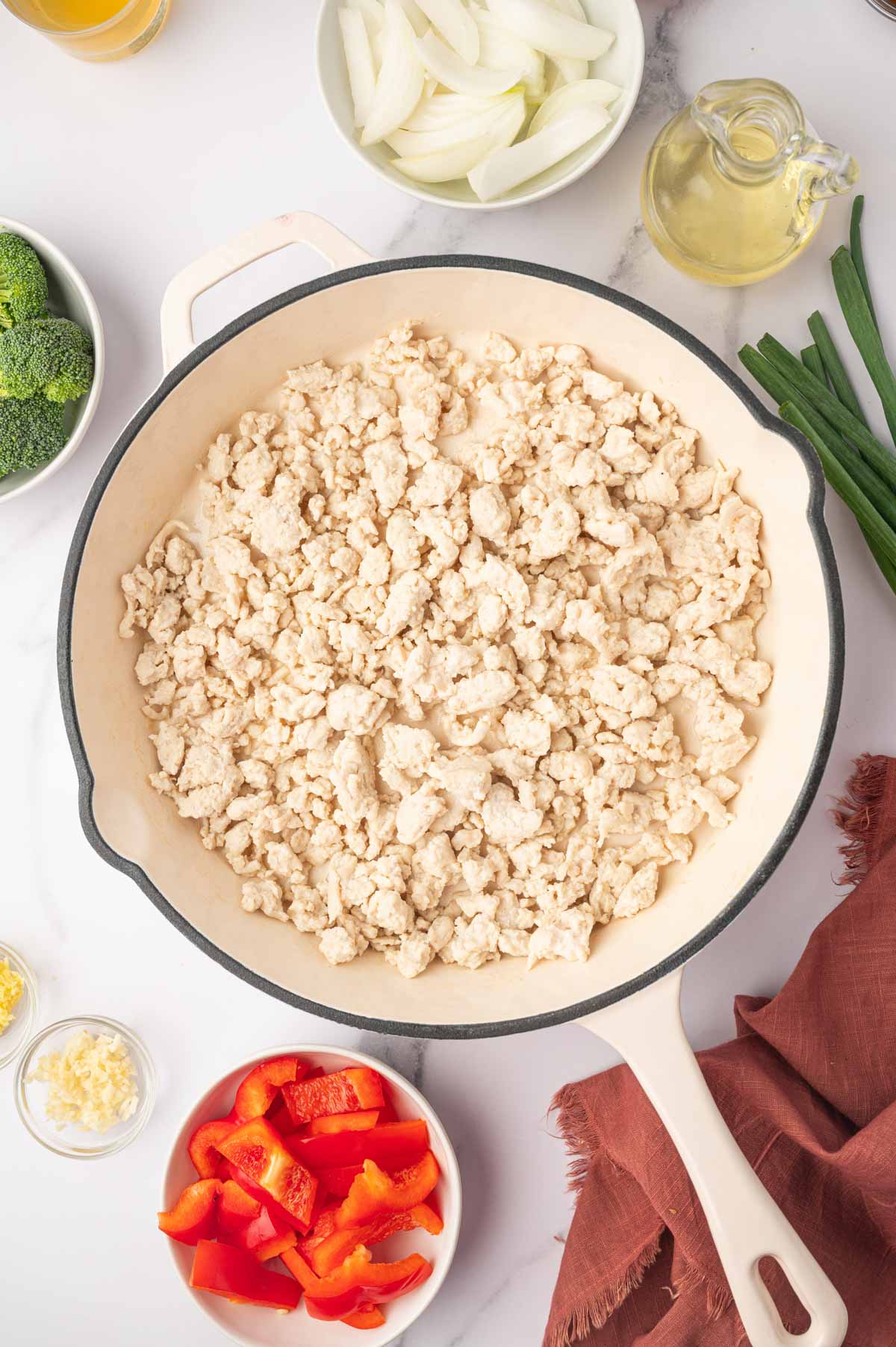 Cooked ground chicken in a white skillet.