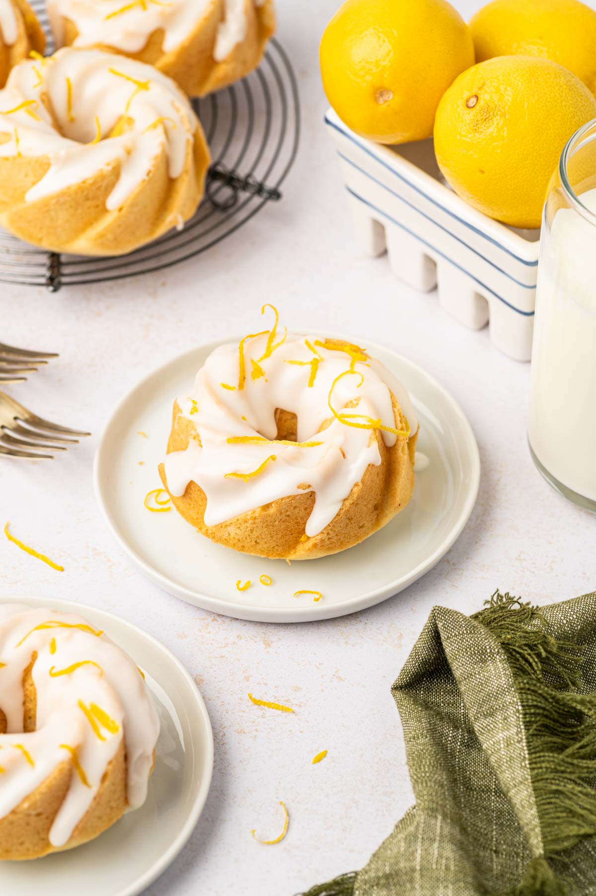 Mini lemon bundt cakes drizzled with lemon glaze on top and in sides lemon  and milk.