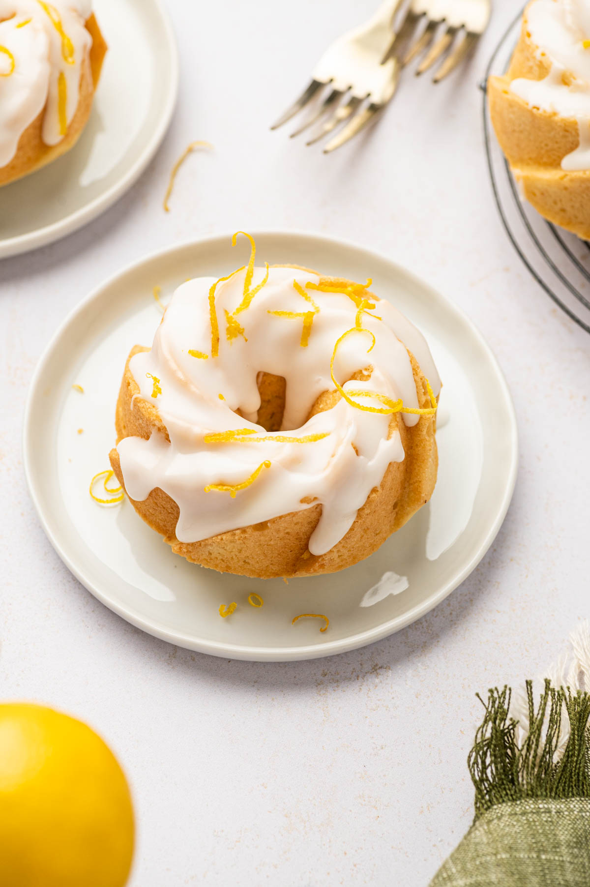 Back light shot of lemon mini bundt cake in a white plate.