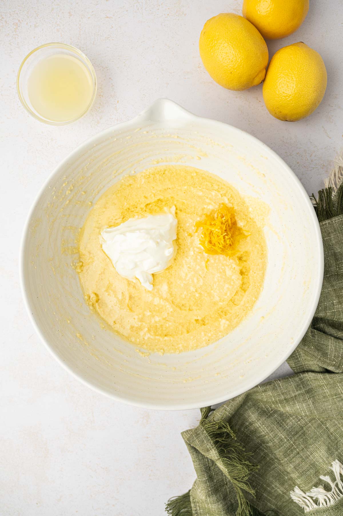 Sour cream and wet mixture in a white bowl for making mini bundt cakes.