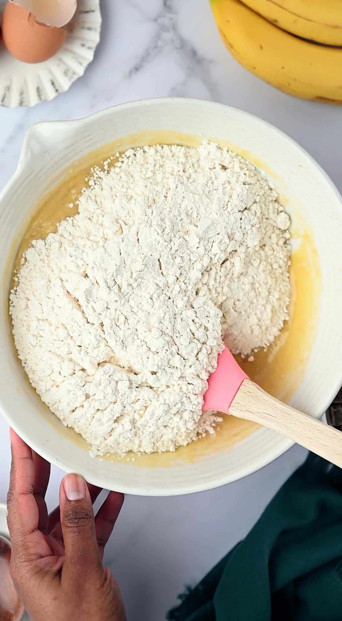 Dry ingredients add the wet mixture for Banana Chocolate Chunks Muffins recipe.