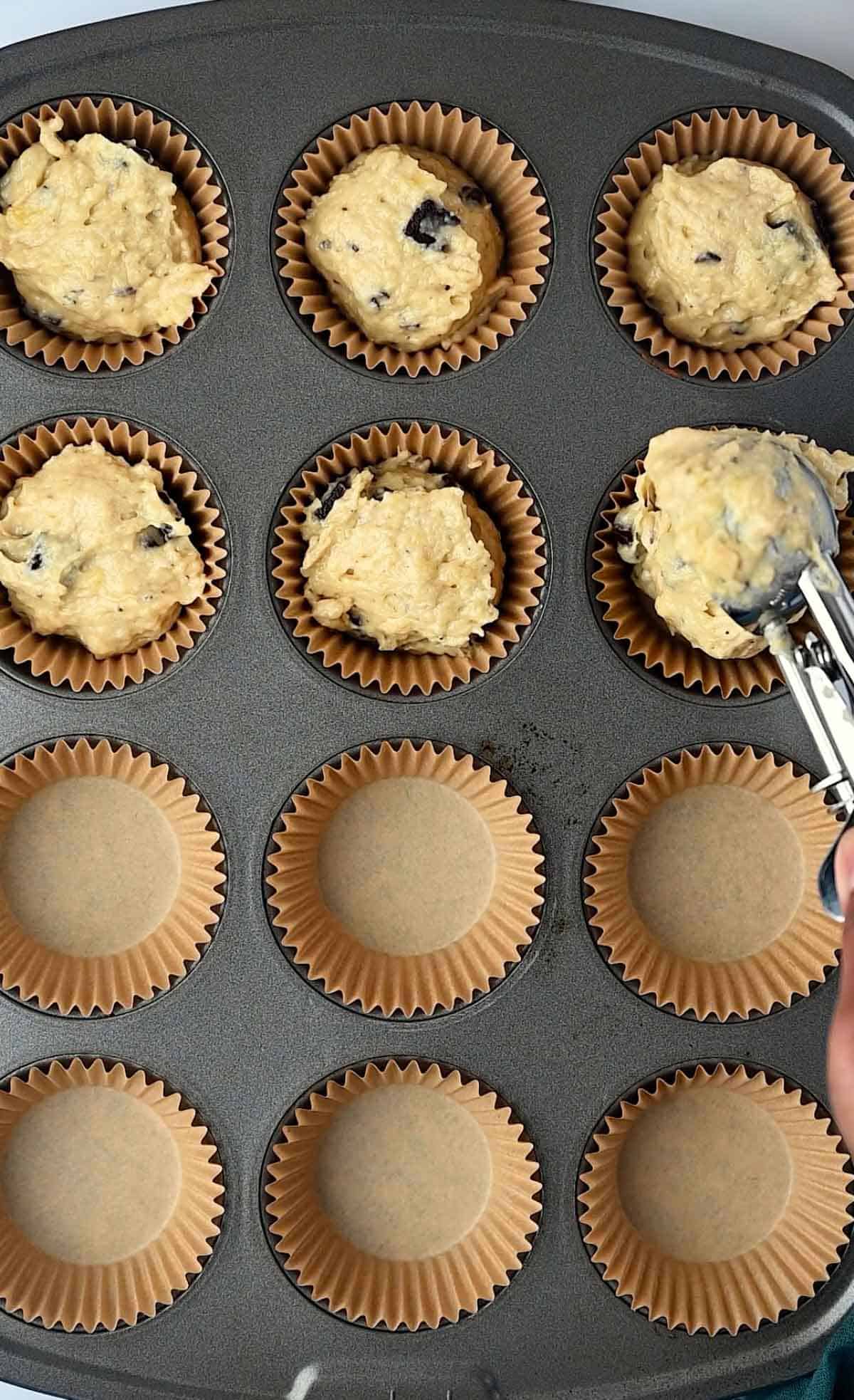 Banana Chocolate Chunks Muffin batter added to the muffin panusing an ice cream scoop.