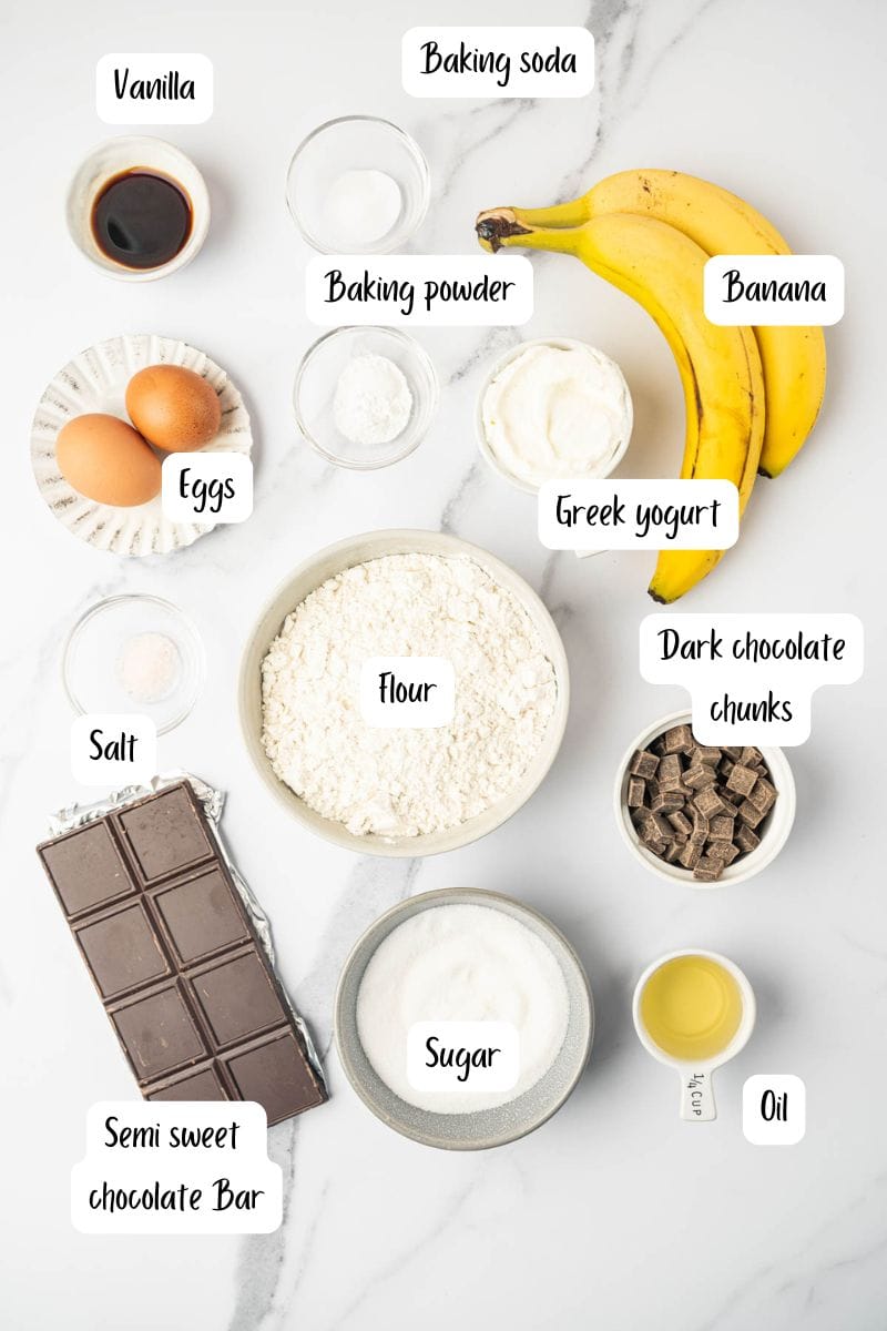 Ingredients of banana chocolate chunks muffins placed in a marble surface.