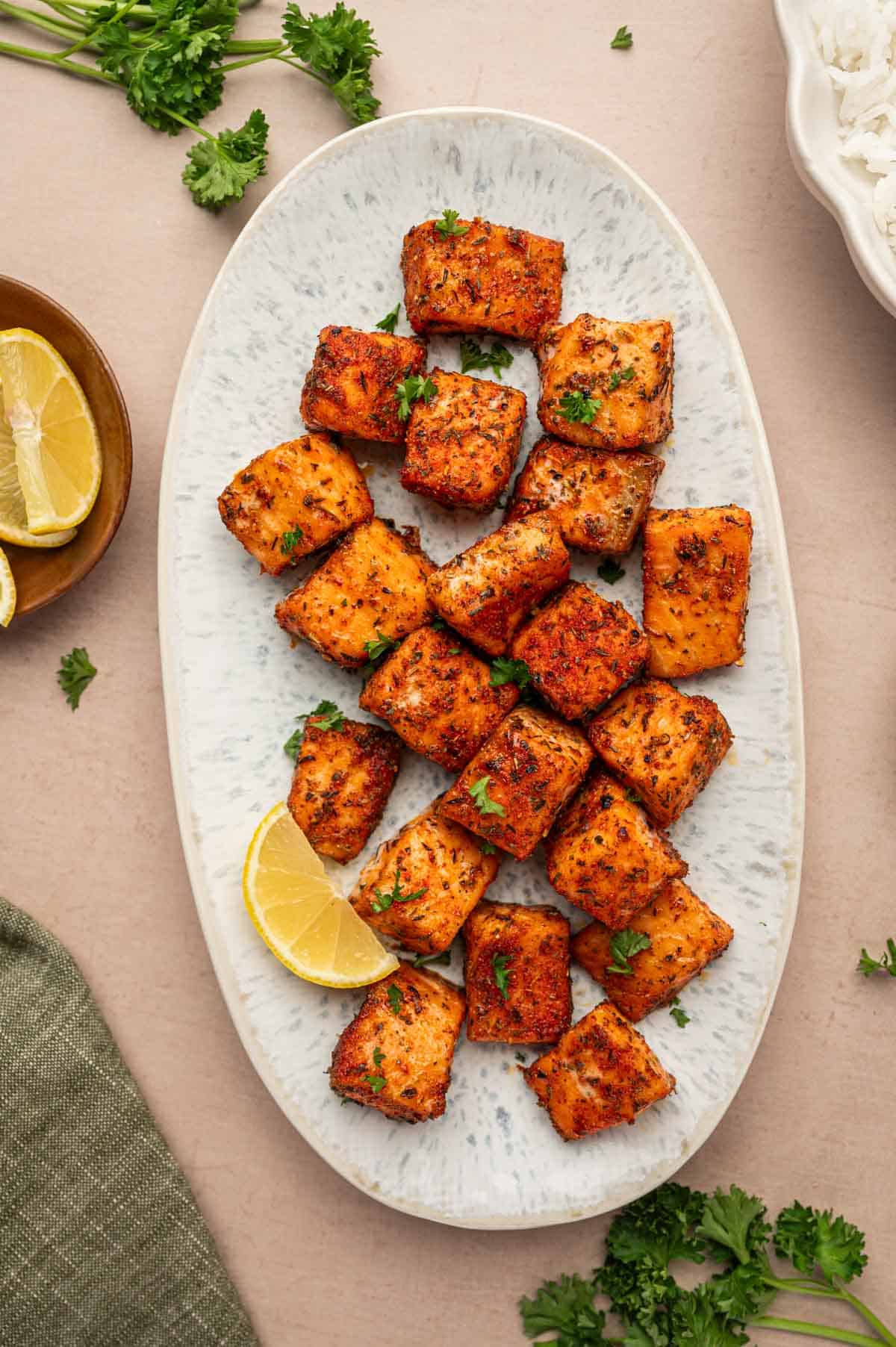 In a oval platter the blackened salmon bites are arranged to serve.