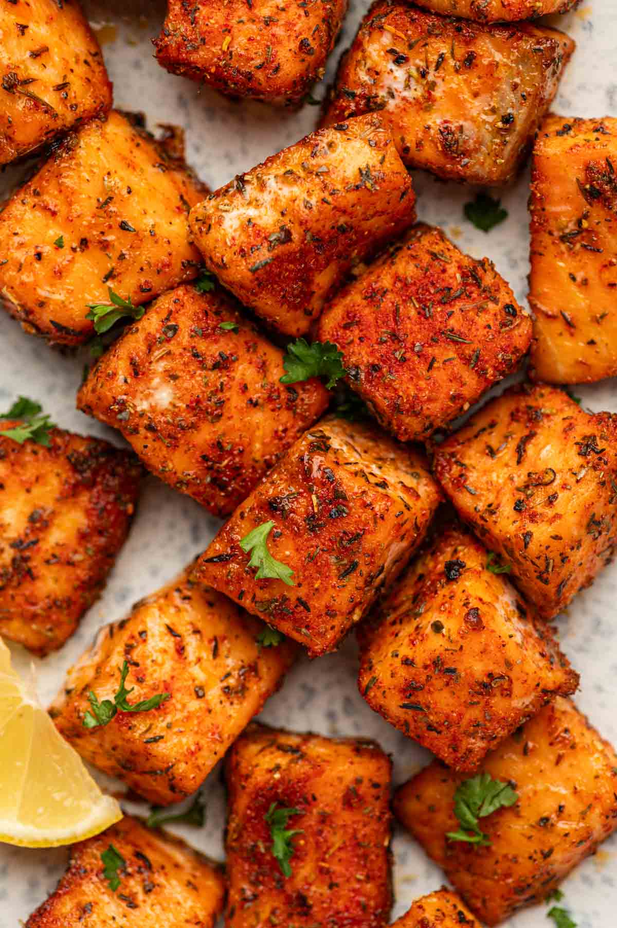 Blackened salmon bites in a close up shot ganrished with parsley.