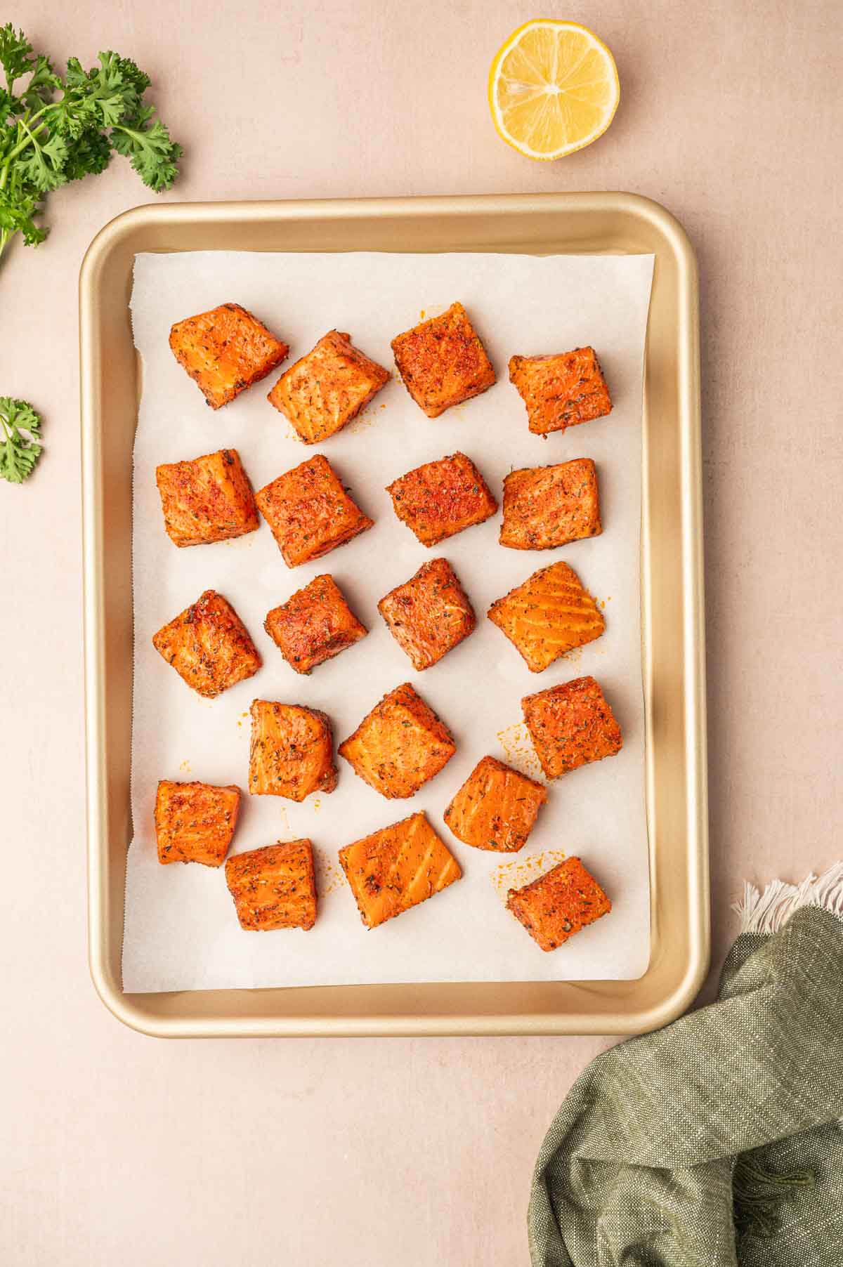 Seasoned salmon bites ready to bake in a baking tray.