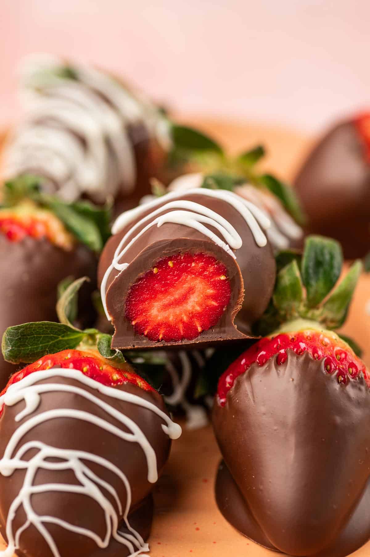 Strawberry covered in nutella and dark chocolate and bite taken to see inside.