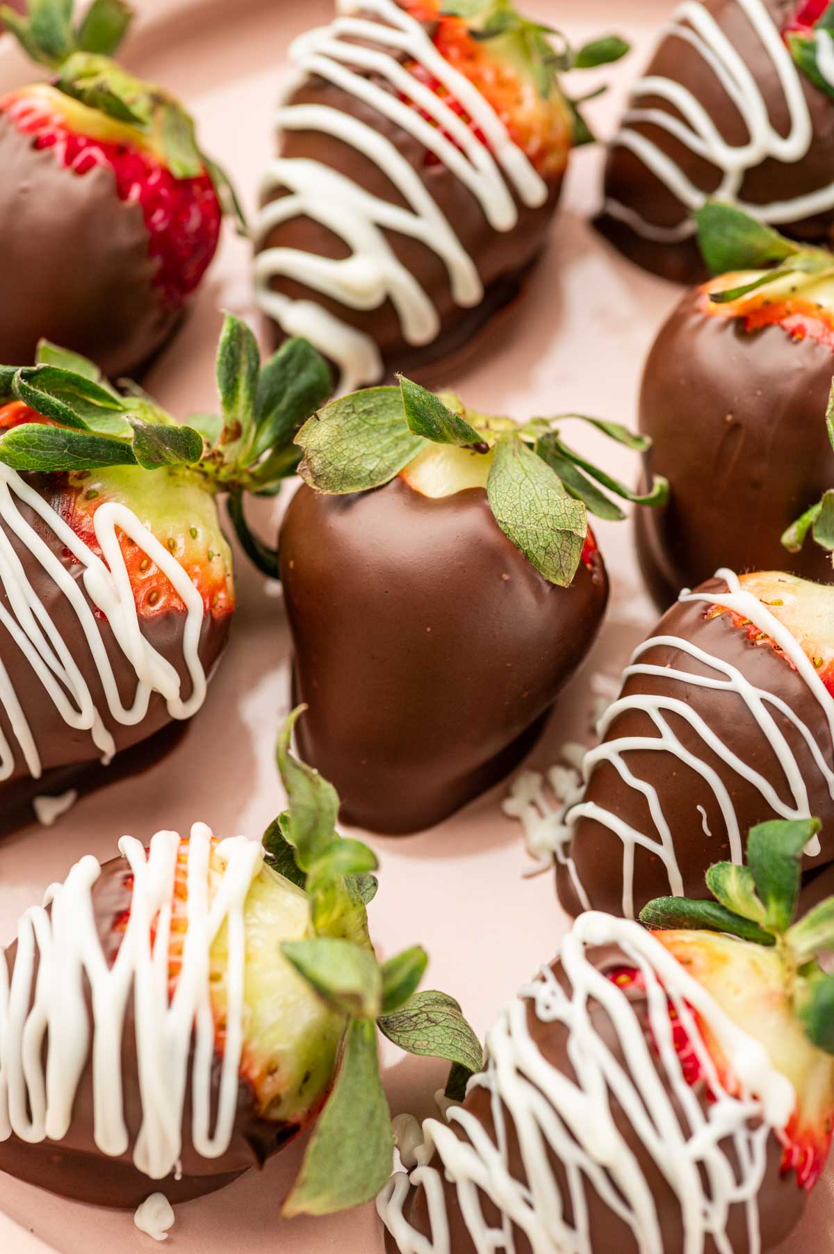 Close up shot of Nutella covered strawberries in a pink plate.