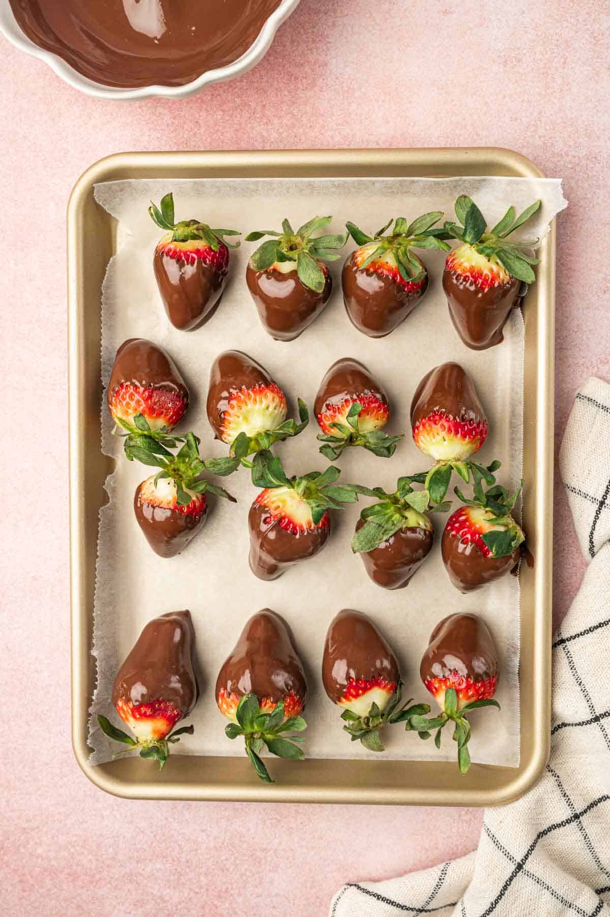 Nutella covered strawberries placed in a baking tray.