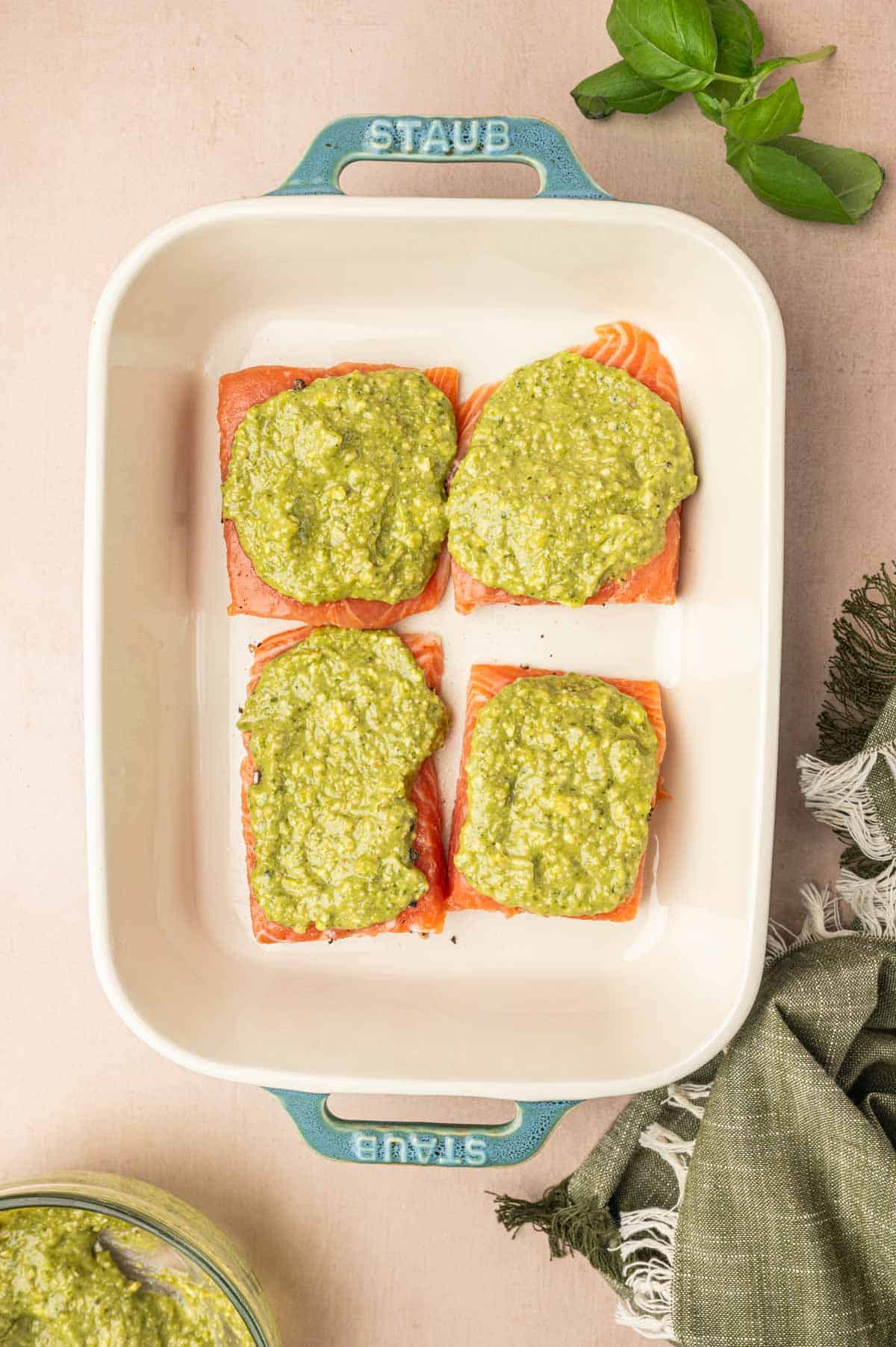 Pesto butter added to the salmon and placed in a baking dish.