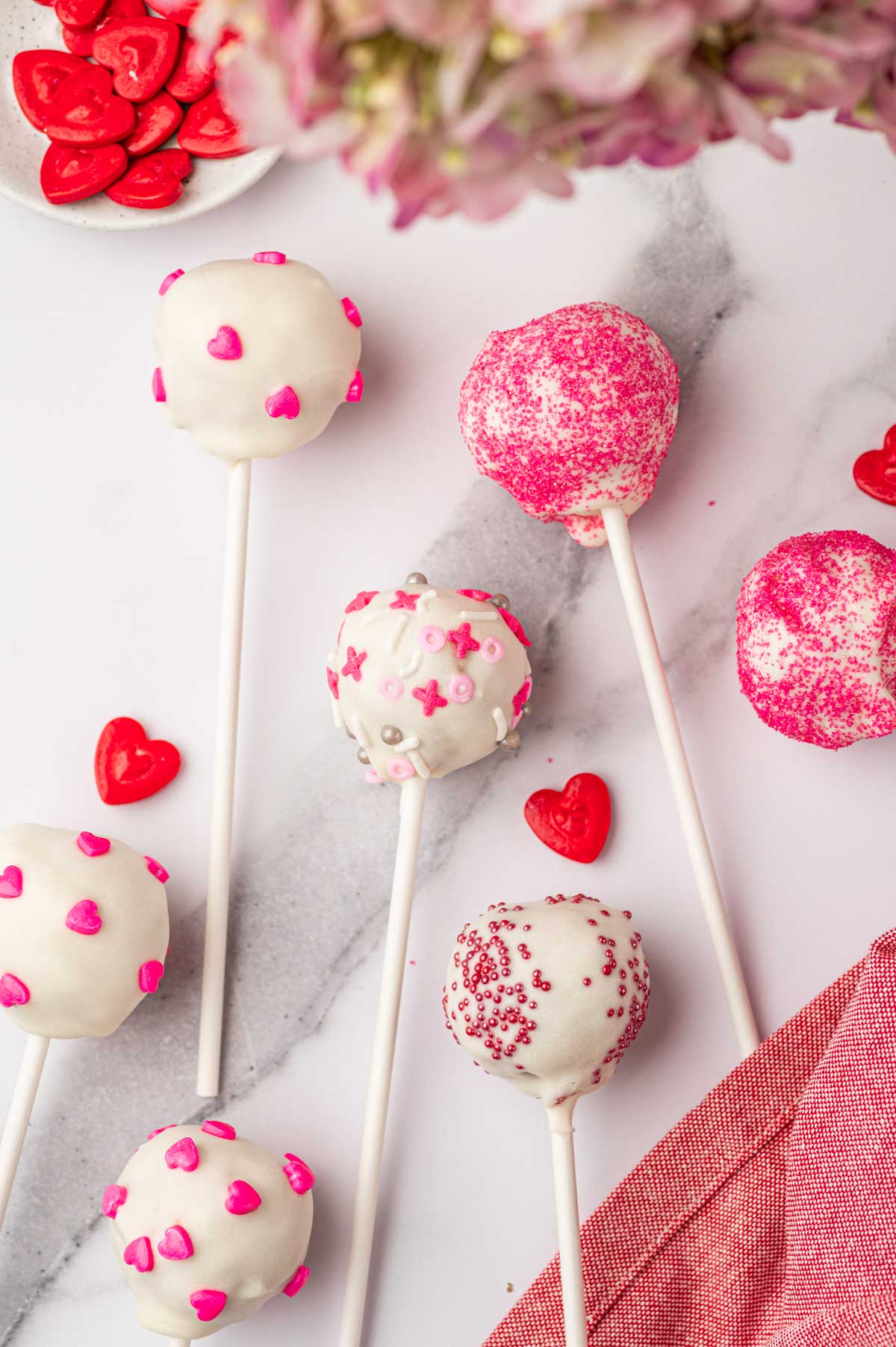 Beautifully decorated valentines cake pops arranged in a marble table.