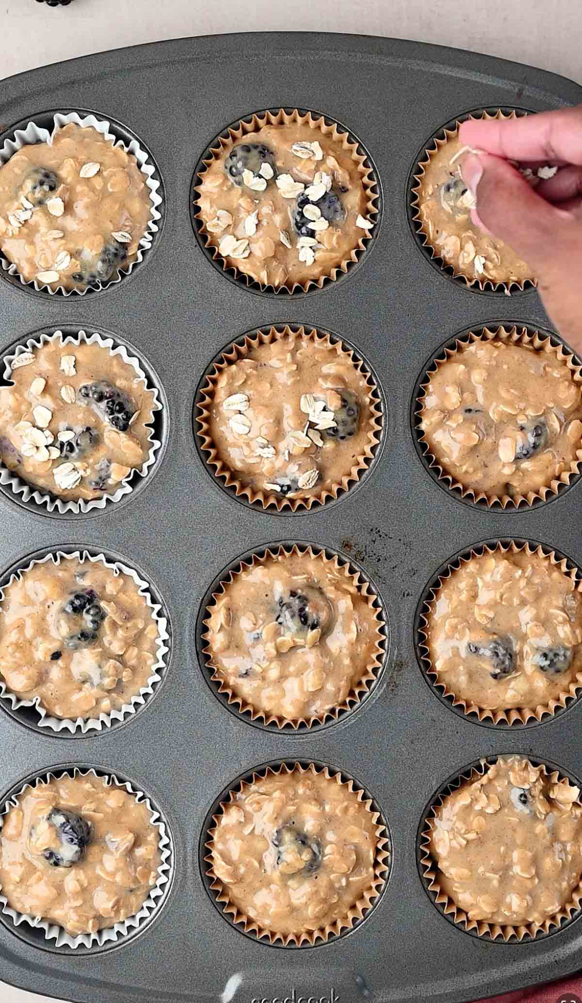 Banana Blackberry Oatmeal Muffin batter is poured in a muffin pan and ready to bake.