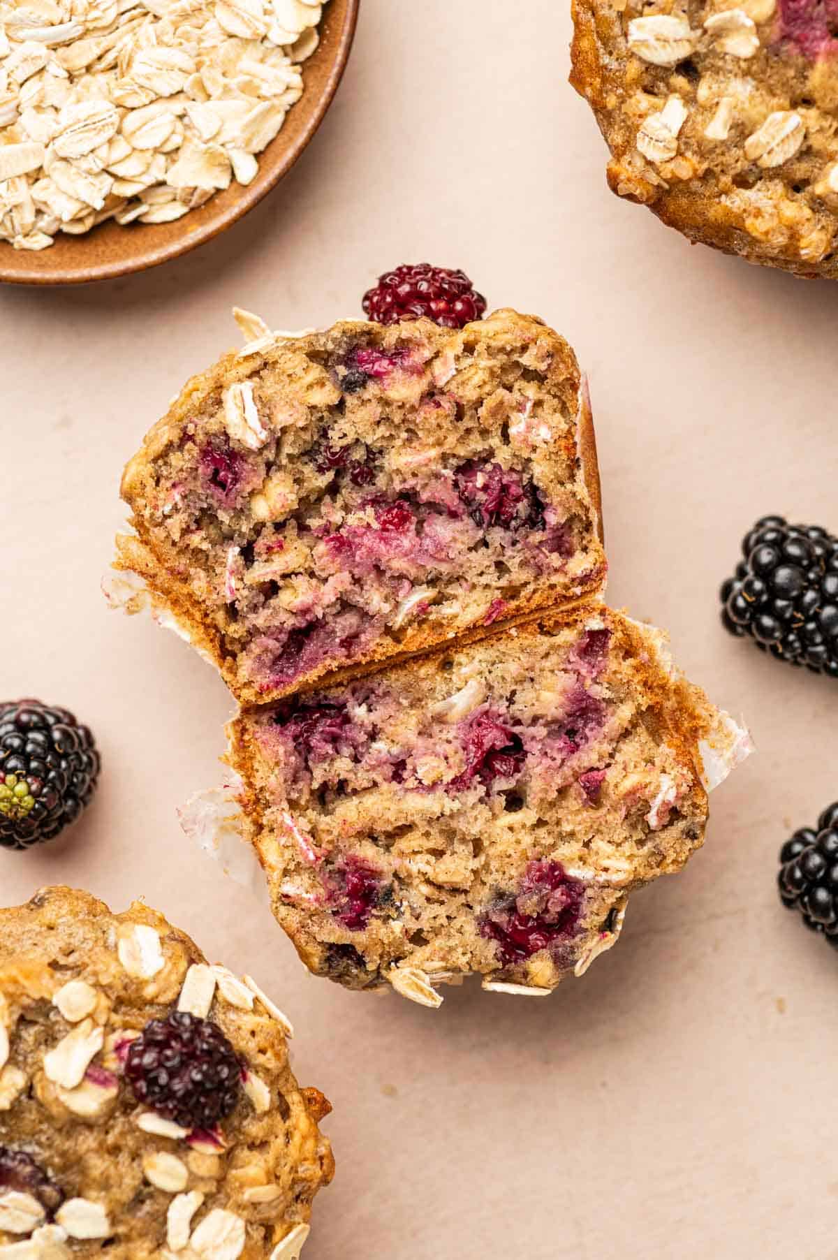 The banana blackberry oatmeal muffins sliced into halves to show the texture of the muffins.