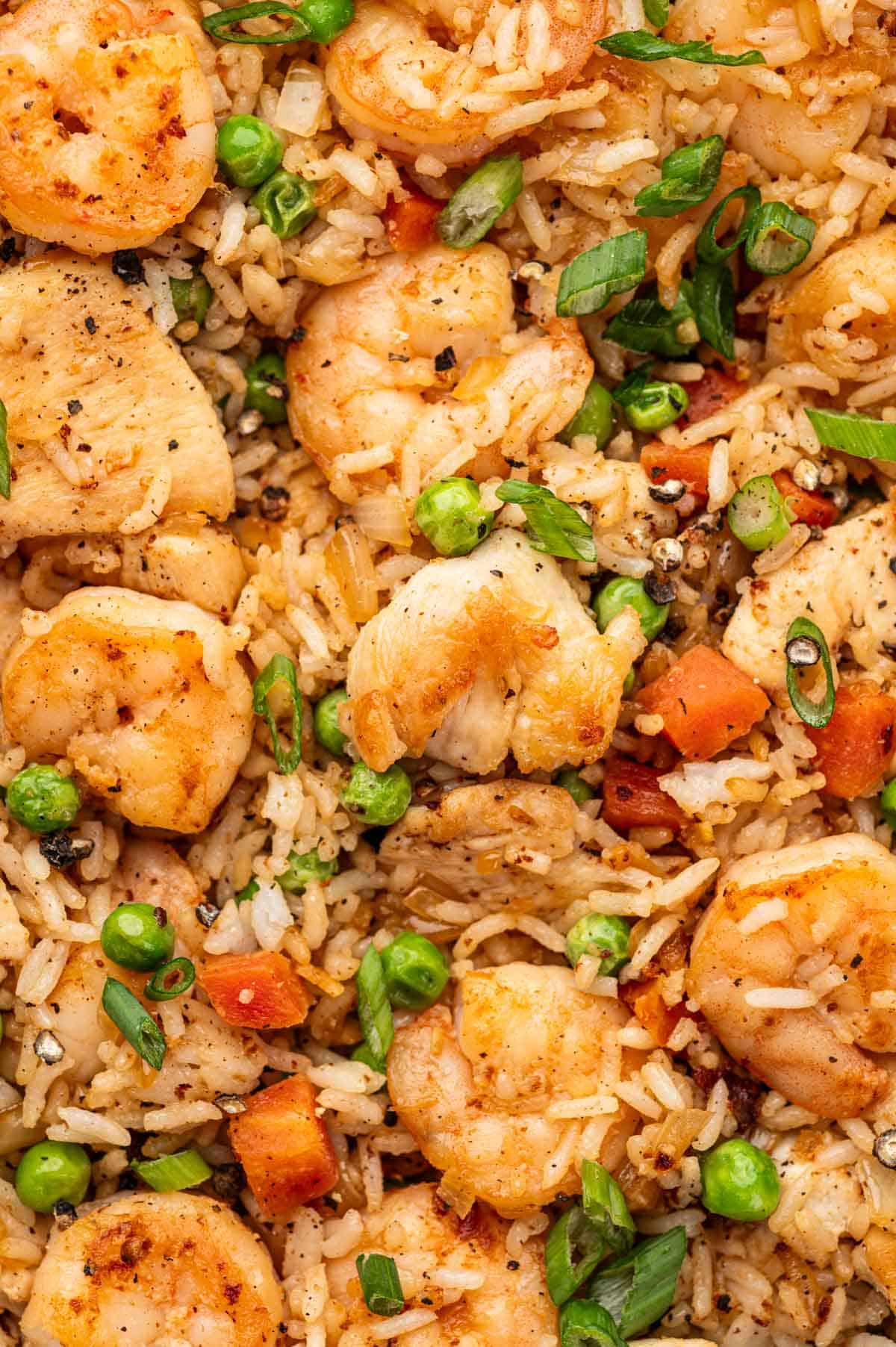 Close up shot of shrimp, chicken pieces and other ingredients in Chicken and shrimp fried rice recipe.