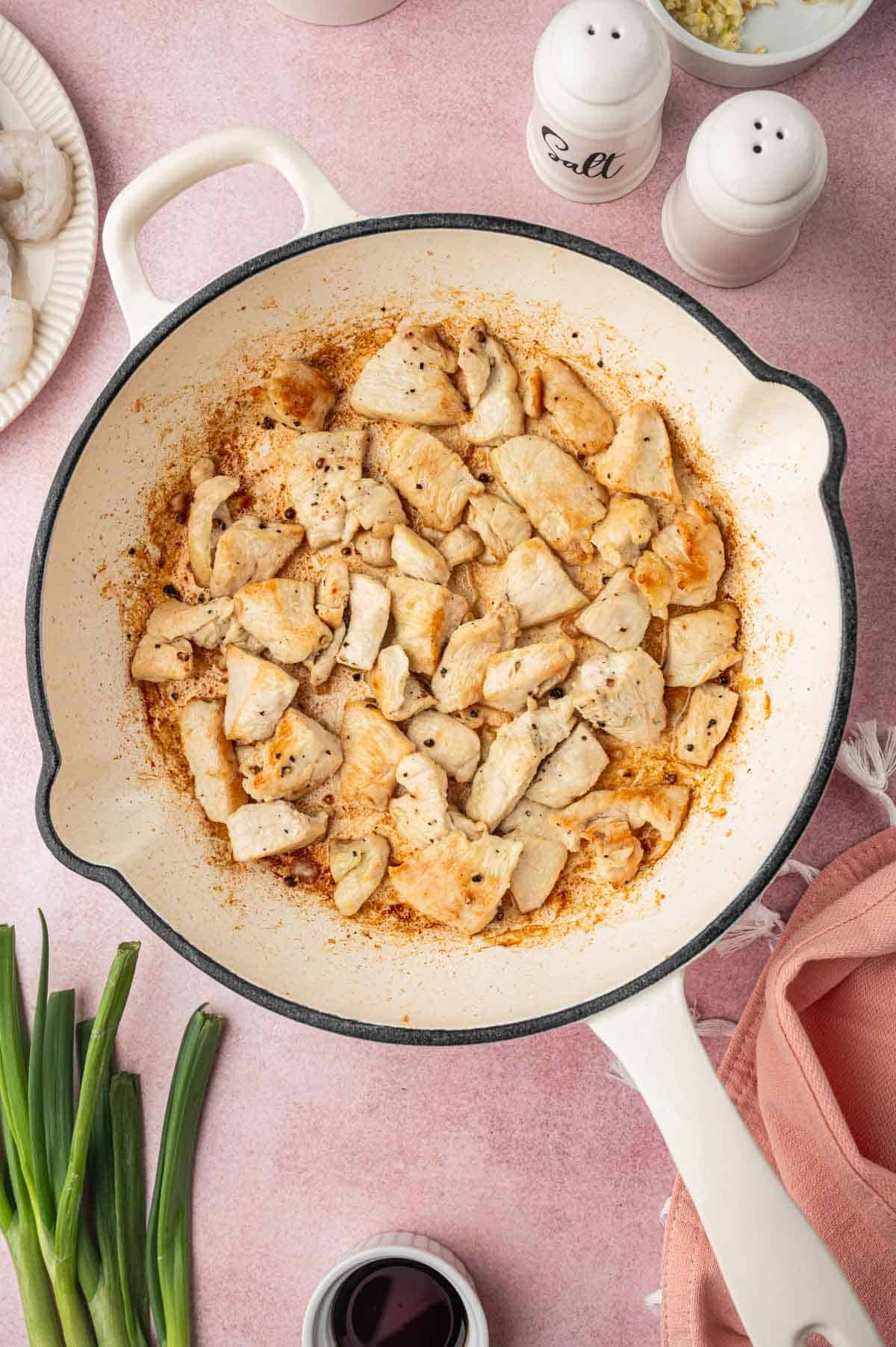 Cooked chicken pieces in a skillet for Chicken and shrimp fried rice recipe.