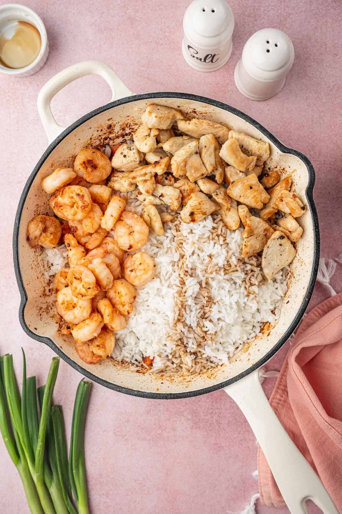 Cooked chicken, shrimp, rice and sauce in the skillet for Chicken and shrimp fried rice recipe.