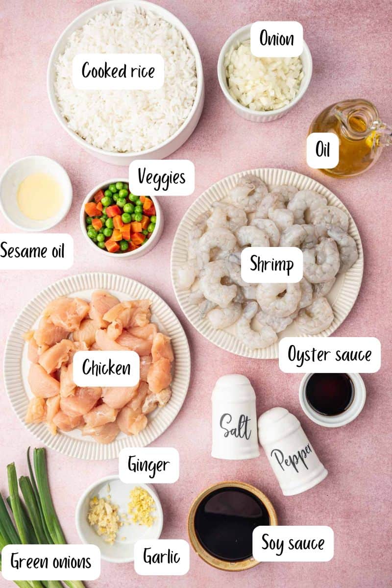 Chicken and shrimp fried rice ingredients laid out on a pink background.