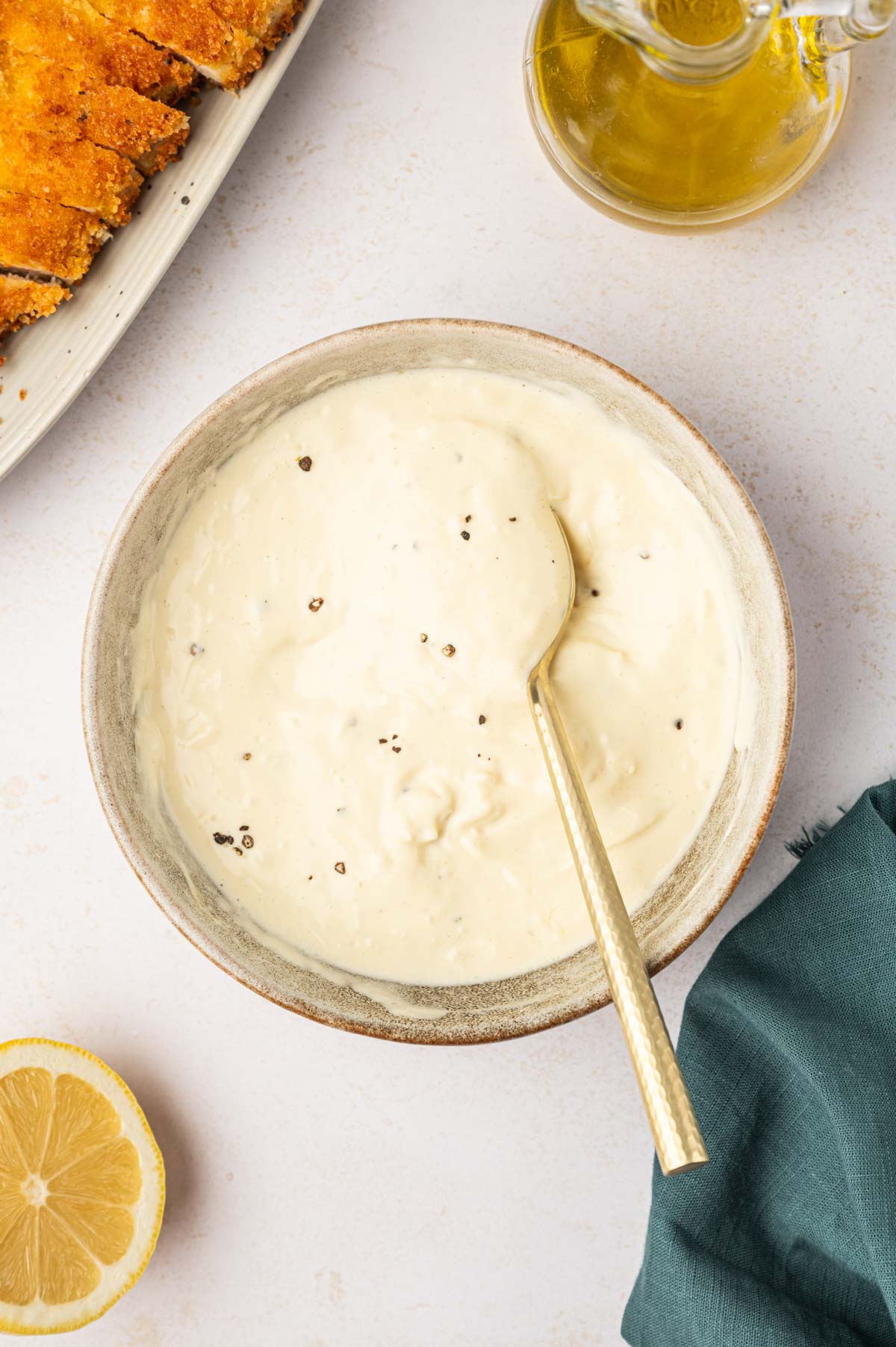 Homemade caesar salad dressing without anchovies in a bowl with a spoon.