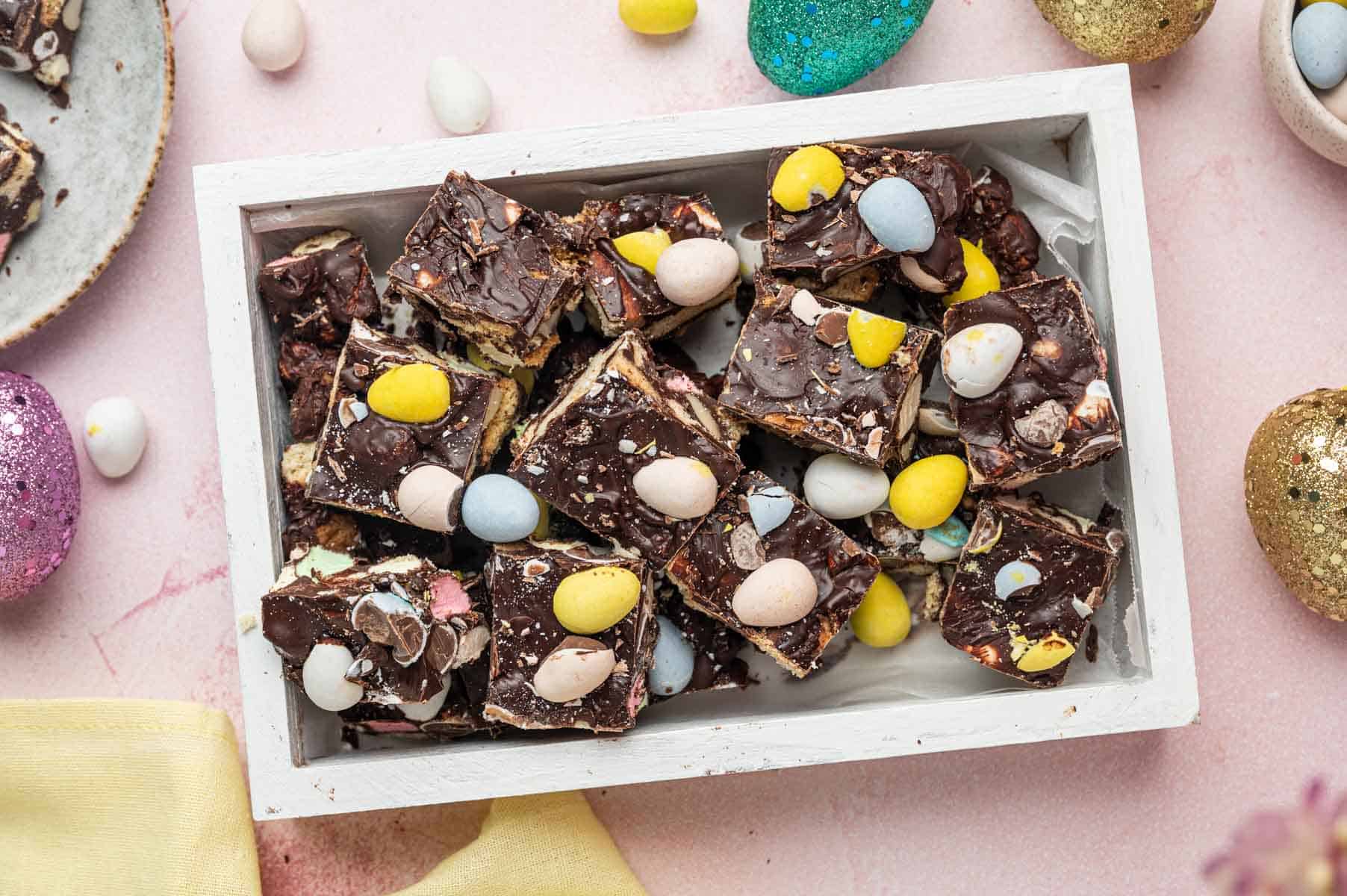 Horizontal image of homemade Easter Rocky road fudge filled a square tray beautifully decorated with easter items.