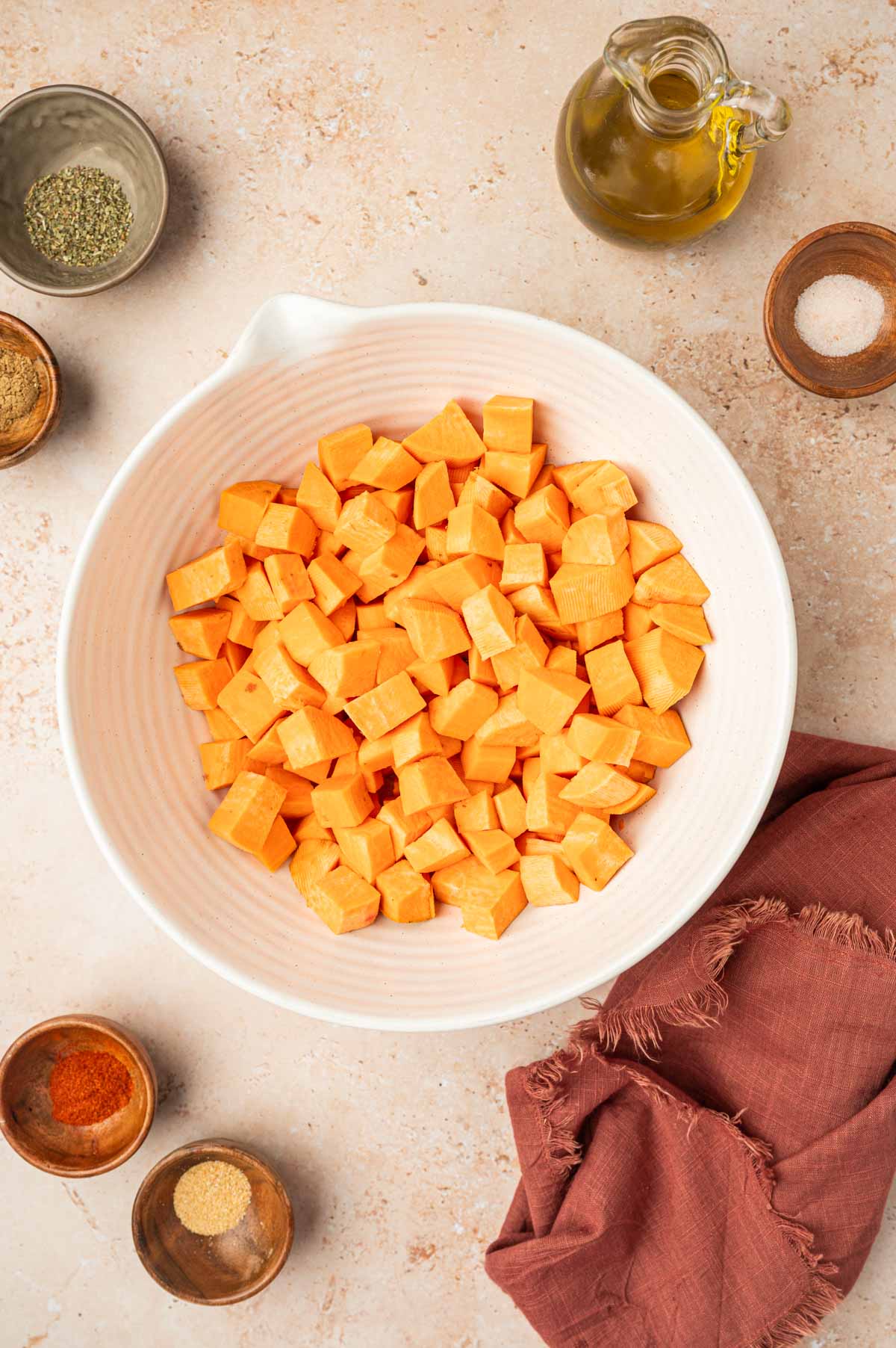 A bowl of cubed sweet potatoes ready to be seasoned.