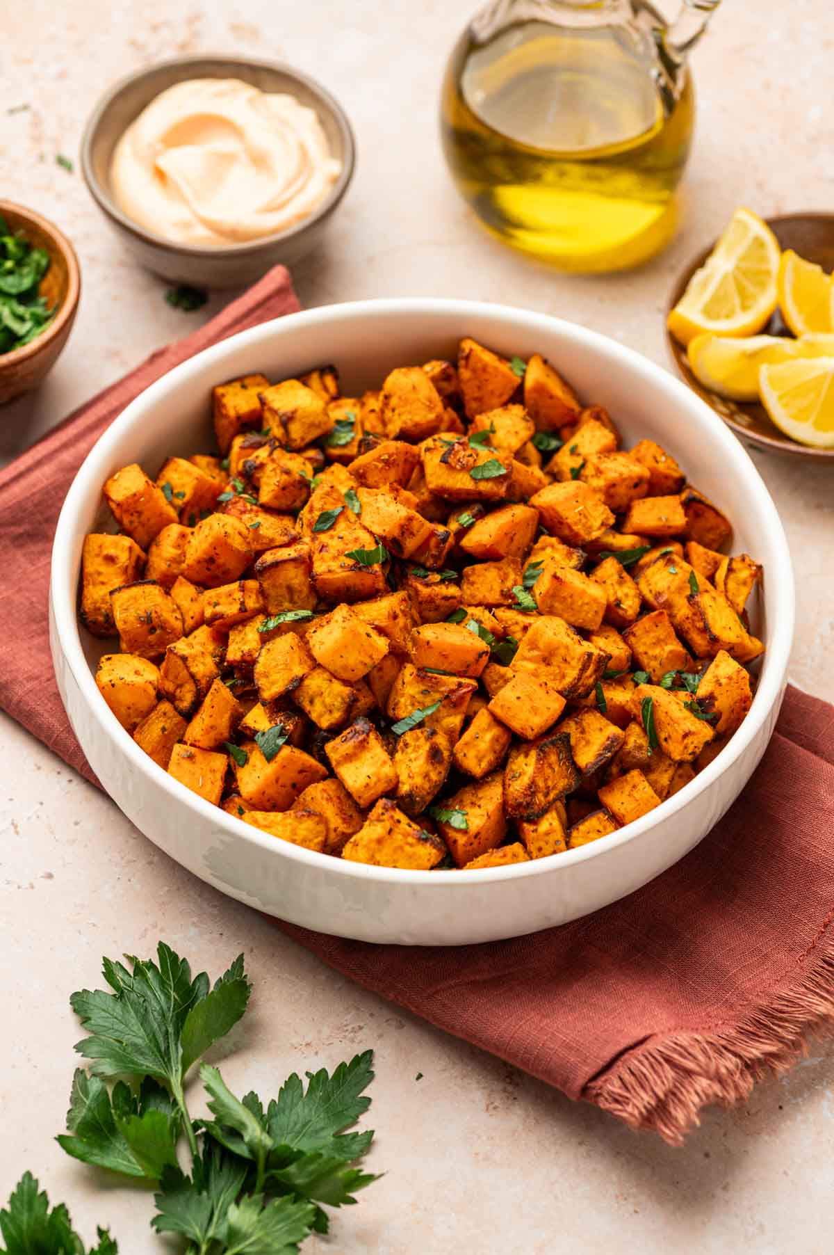 Crispy air-fried sweet potato cubes served in a bowl, garnished with fresh herbs.