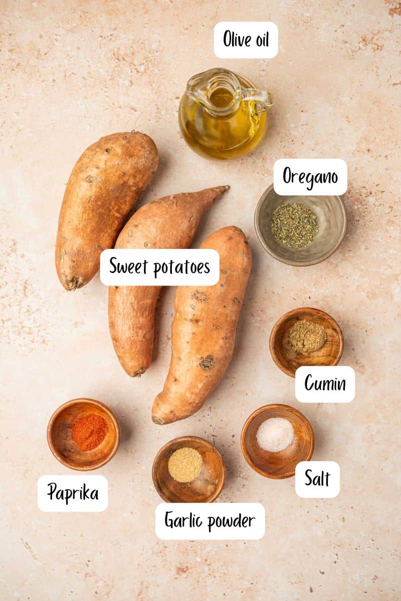 Overhead view of air-fried sweet potato cubes recipe ingredients laid out on a warm neutral backdrop.