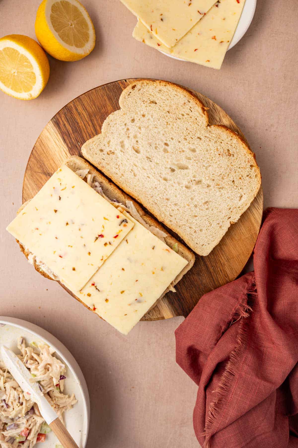 The chese slice being arranged on top of the mixture while making chicken salad melt sandwich recipe.