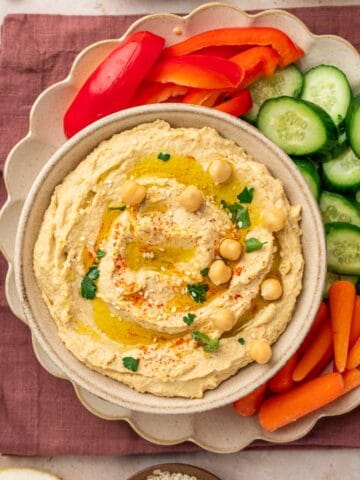 Delicious and smooth hummus without garlic, artfully styled on a bowl with vibrant veggies and , perfect for dipping.