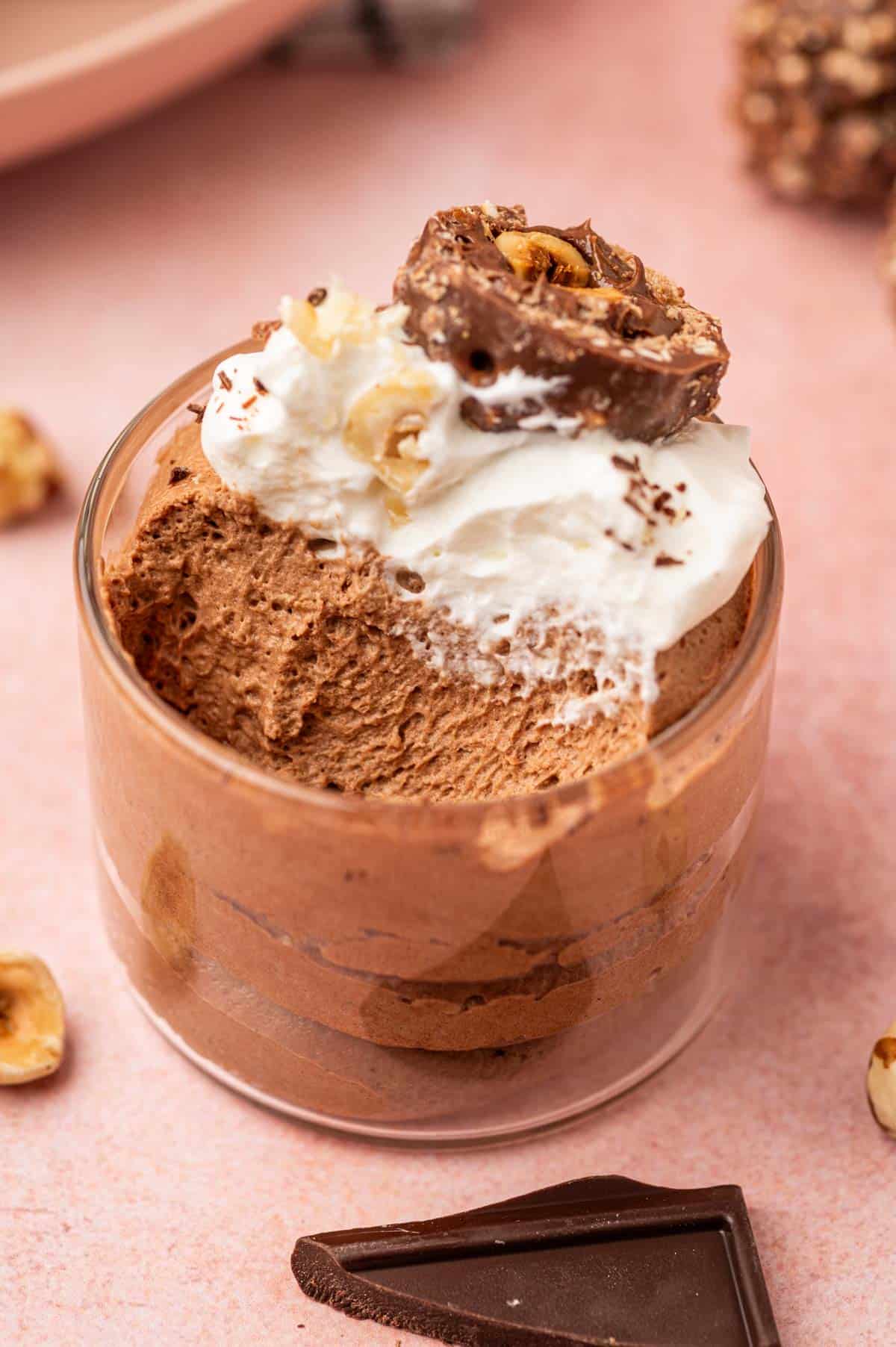 Rich and airy Nutella mousse served in a clear glass bowl, with a spoonful taken out, showing its smooth texture.