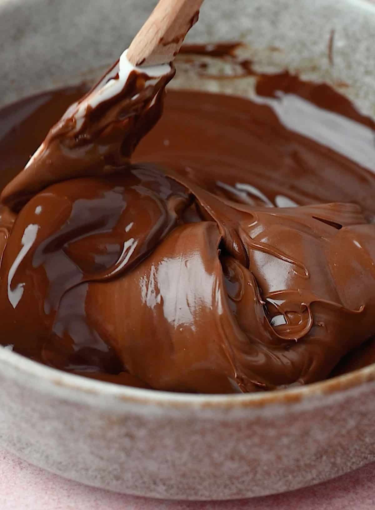 Nutella being added to the melted chocolate for making the best no bake chocolate mousse.