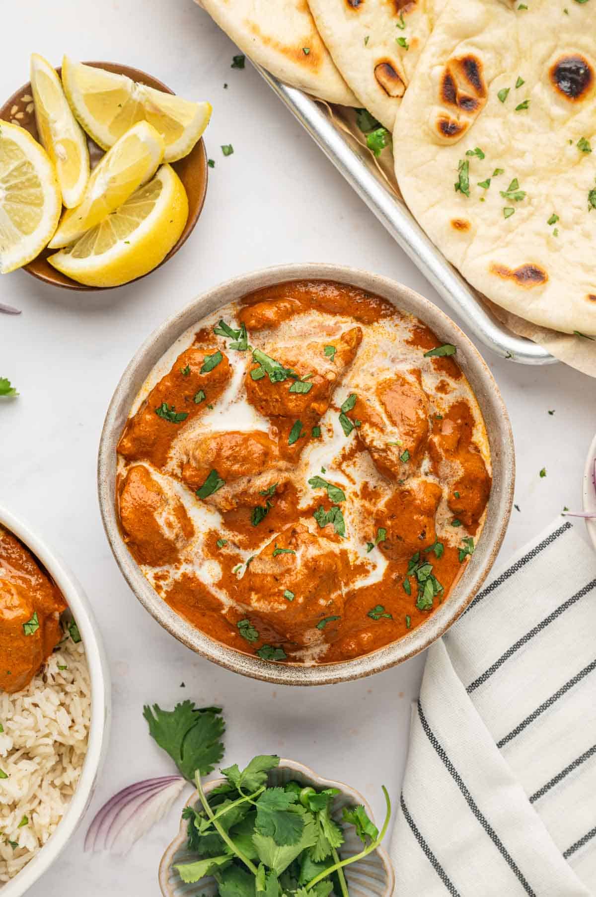 Authentic Indian butter chicken with soft garlic naan and fresh cilantro garnish.