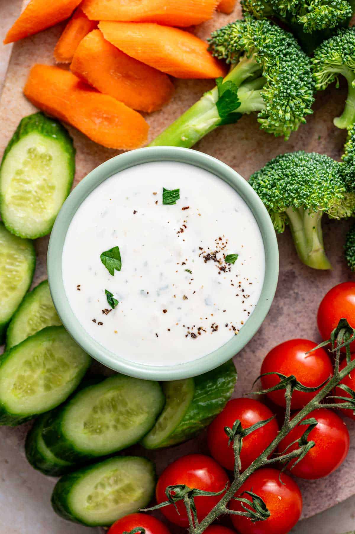 Parmesan ranch dip styled with a veggie platter on a wooden board.