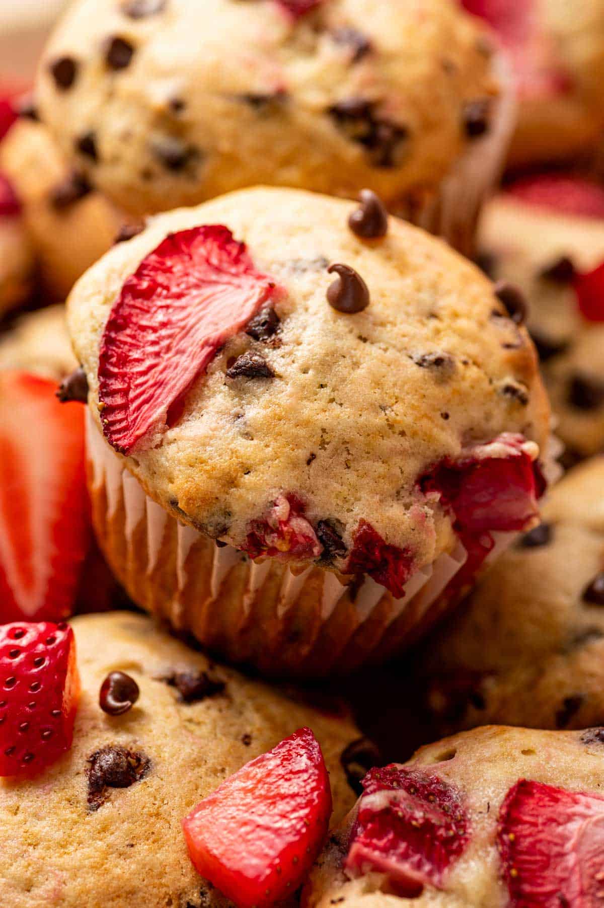 Close-up of a moist strawberry muffin with melted mini chocolate chips.