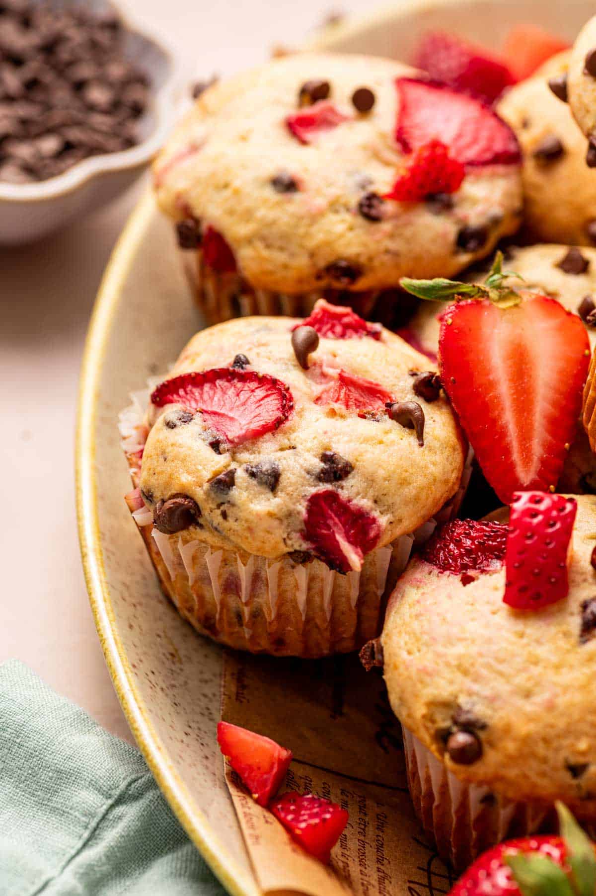 Close-up of a moist strawberry muffin with melted mini chocolate chips in a platter.